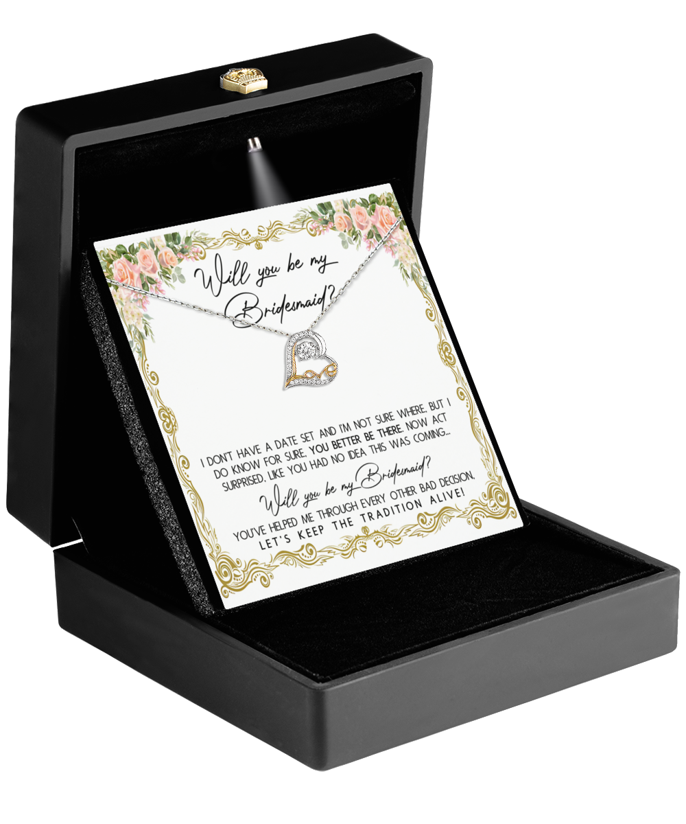 A beautifully designed black jewelry box showcases the Bridesmaid-Keep The Tradition - Love Dancing Necklace. Inside, a card with floral edges poses the question "Will you be my bridesmaid?" alongside a heartfelt message, making it an ideal gift for your bridesmaids.