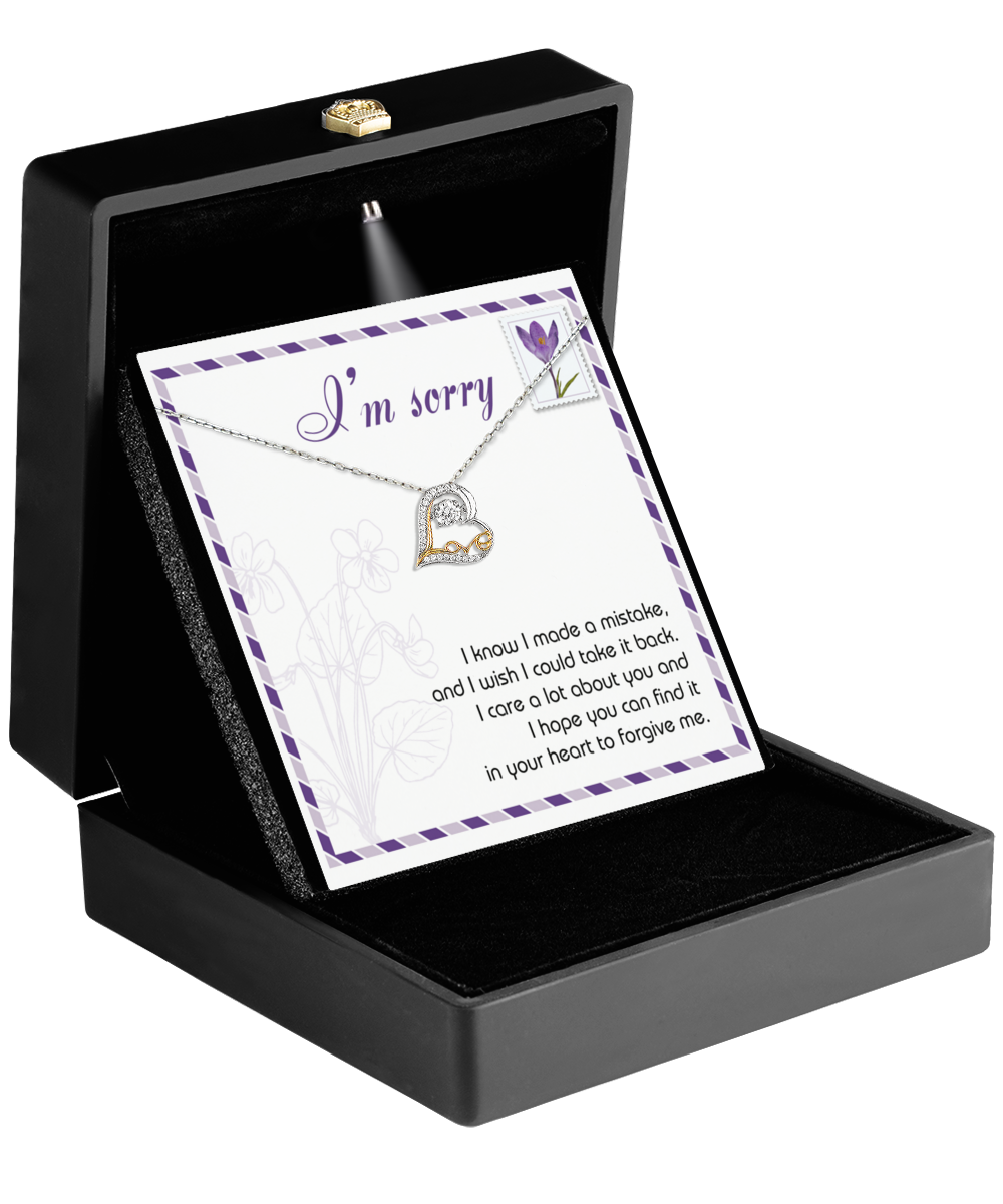 The Sorry-Take It Back - Love Dancing Necklace features a 14k gold heart-shaped pendant in a black box, along with an "I'm sorry" card and apology message.