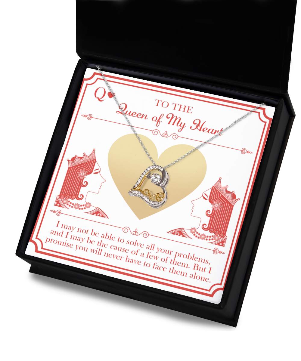 The "To Wife-The Queen - Love Dancing Necklace," a 14k gold necklace with an intertwined heart pendant adorned with crystals, is elegantly presented inside a black gift box. The interior lid of the box showcases a card featuring illustrations of a queen of hearts playing card theme, accompanied by a heartfelt message.