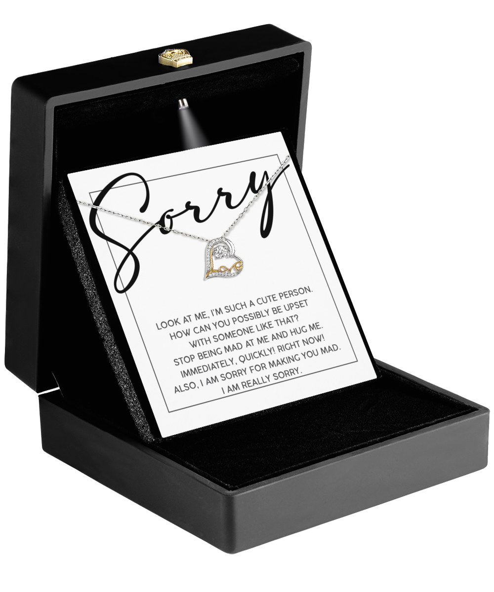 A black jewelry box unveils the Sorry-Someone Like That - Love Dancing Necklace on a card, featuring "Sorry" in bold script paired with a sparkling silver heart, expressing both regret and affection.