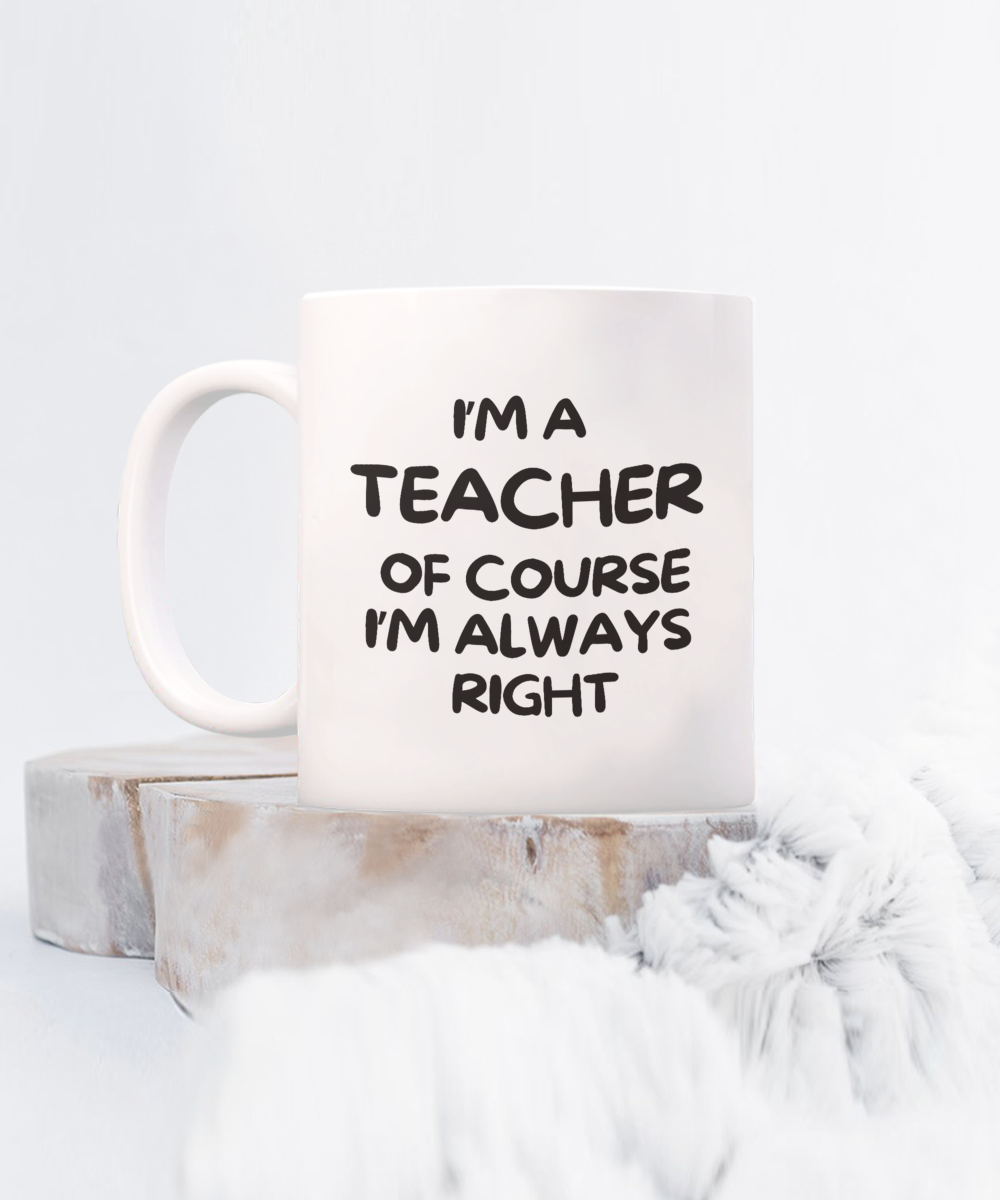 The "I'm A Teacher Of Course I'm Always Right" coffee mug rests on wooden rounds and a fluffy surface. Order this charming cup now to enhance your collection!.