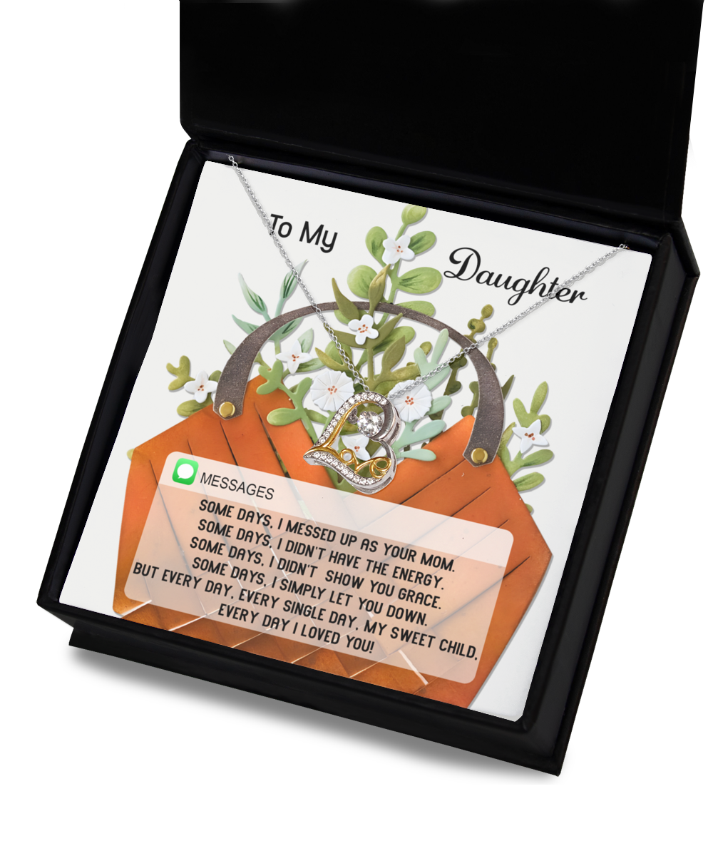 A Daughter-Show You Grace - Love Dancing Necklace featuring an intertwined ring pendant shines beautifully in an open black box. Made from sterling silver, it is displayed against a backdrop of flowers and accompanied by a heartfelt message to a daughter.