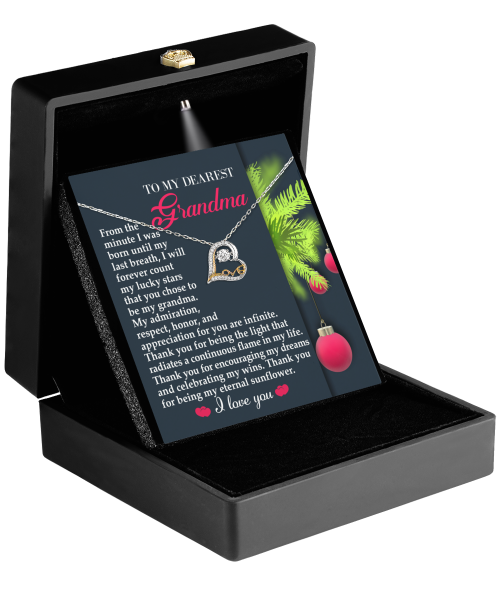 The black box reveals a Grandma-Eternal Sunflower - Love Dancing Necklace and a card for Grandma with red text and a Christmas tree branch design, embodying maternal love.