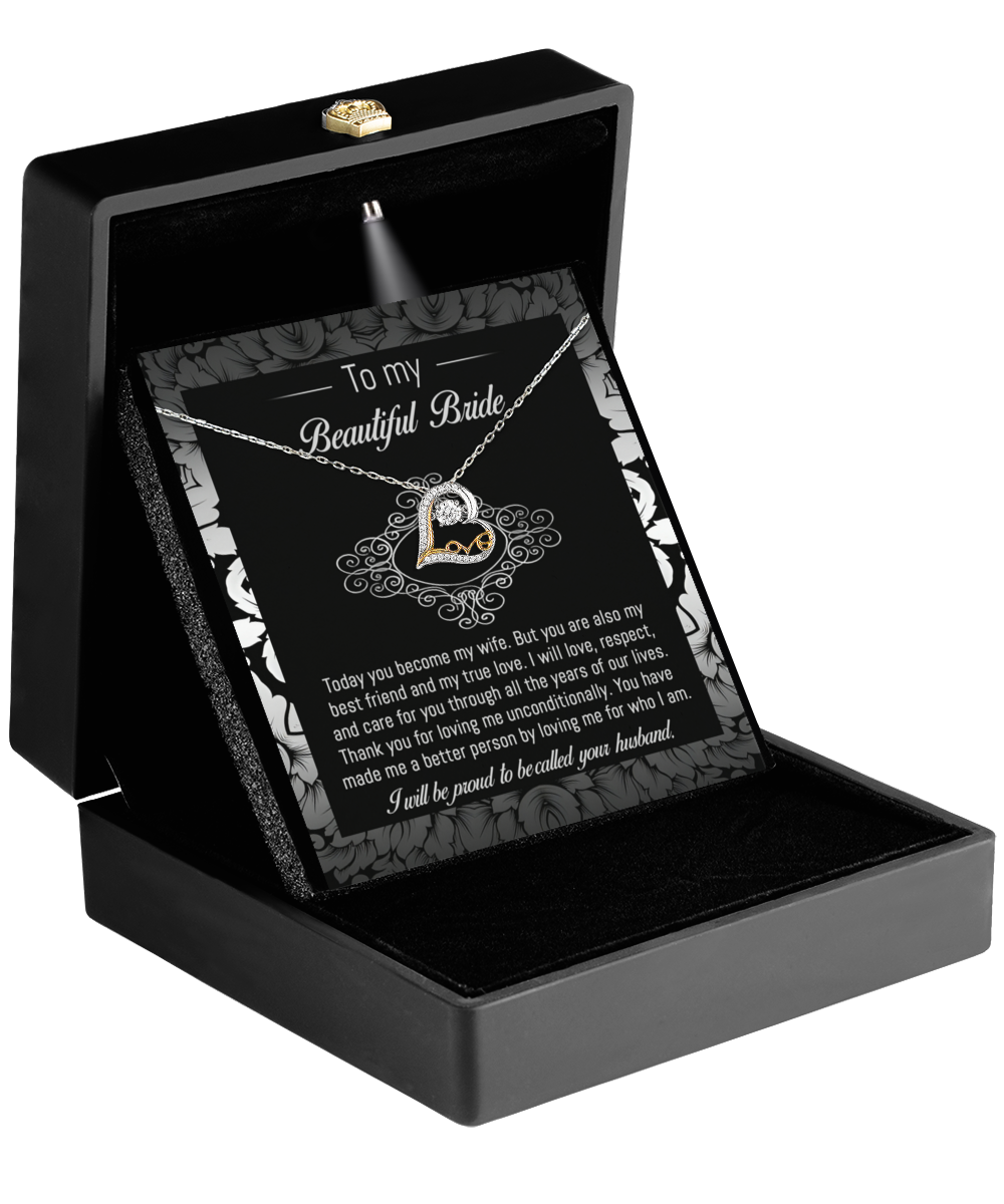 The "To Bride-My True Love - Love Dancing Necklace" is a stunning 14k gold piece featuring a heart-shaped pendant, beautifully presented in a sleek black box. It comes with an emotive message card titled "To my Beautiful Bride," capturing emotions perfectly.