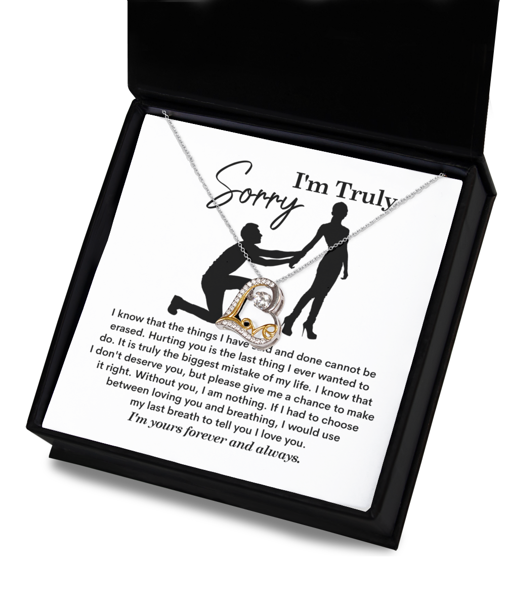 A Sorry-My Last Breath - Love Dancing Necklace, featuring a heart-shaped pendant crafted from .925 Sterling Silver, is placed on top of a note with the heading "I'm Truly Sorry" and an illustration of a person on one knee offering their hand to another person.