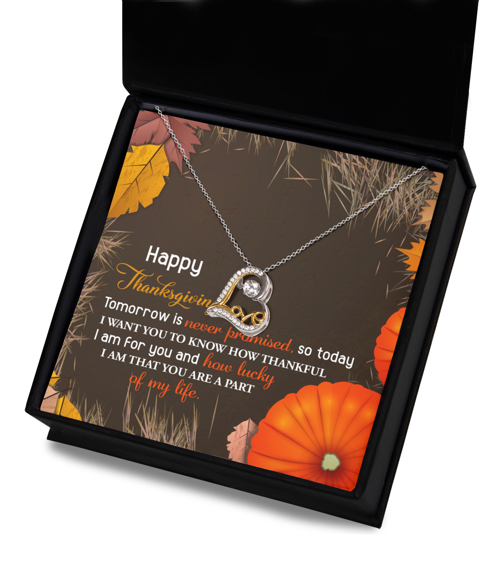 The Thanksgiving-How Lucky - Love Dancing Necklace, crafted in sterling silver, showcases a heart pendant elegantly displayed on a black box. The scene is beautifully framed with autumn leaves and pumpkins, highlighting a heartfelt Thanksgiving message.