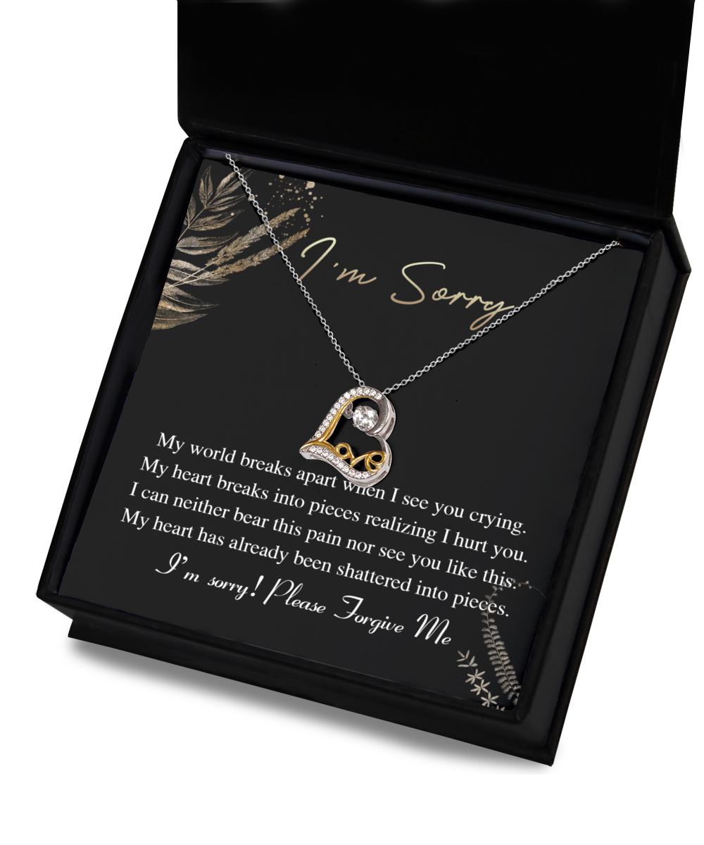 The Sorry-See You Crying - Love Dancing Necklace is a 14k gold triple-plated necklace featuring a heart-shaped pendant, elegantly displayed in an open gift box. The inner lid of the box reads, "I'm Sorry," accompanied by an apologetic message beneath.