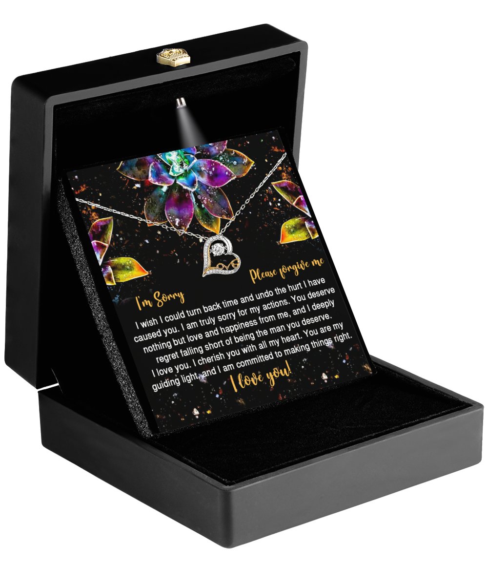 A jewelry box contains the Sorry-All My Heart - Love Dancing Necklace, which features a heart-shaped pendant crafted in 14k gold, along with a card bearing an apology message.