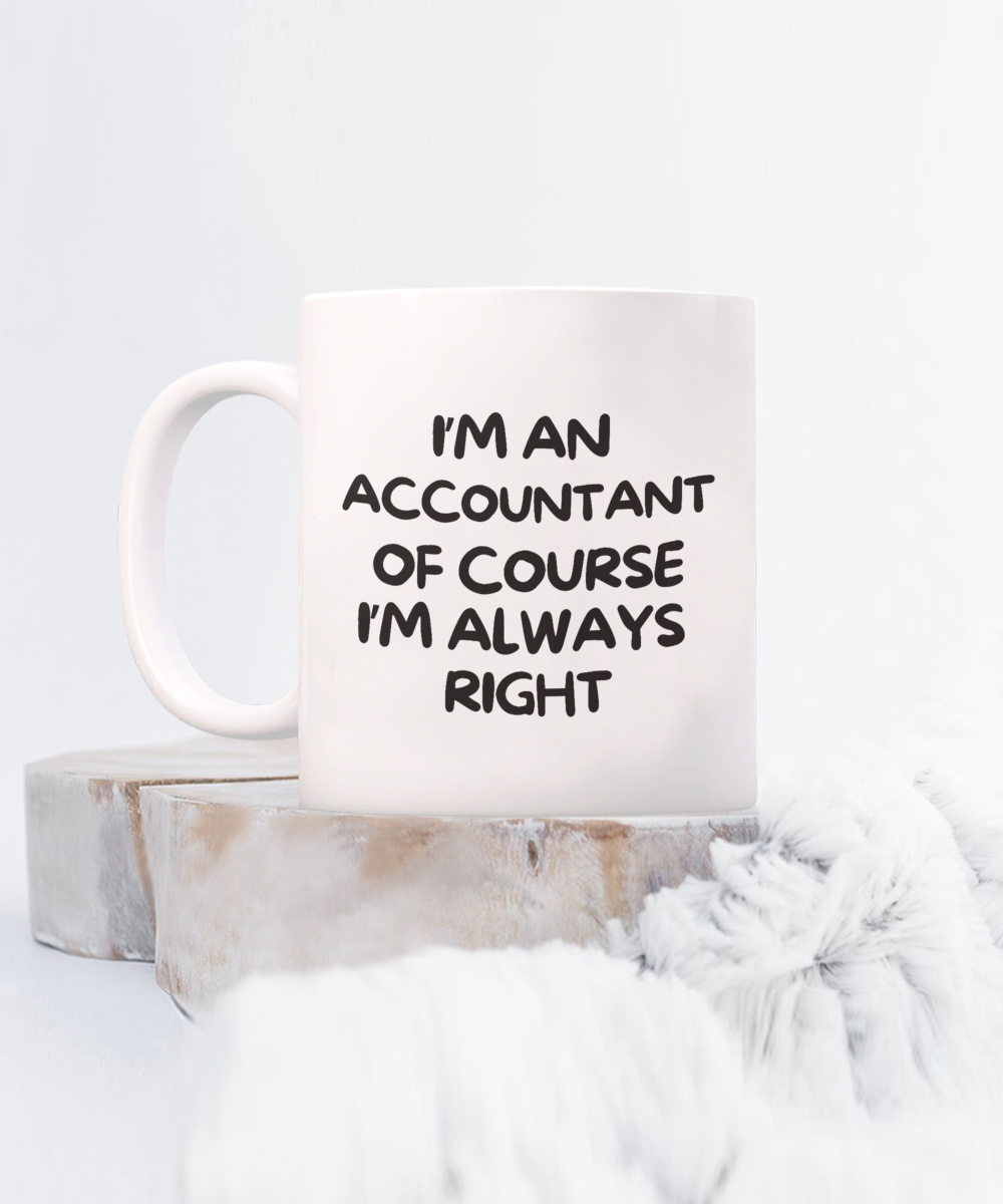 The "I'm An Accountant Of Course I'm Always Right" coffee mug, labeled as the best gift and appreciation cup for accountants, rests on a wooden surface next to a soft blanket. This exclusive item, printed and shipped from the USA, is not available in stores.