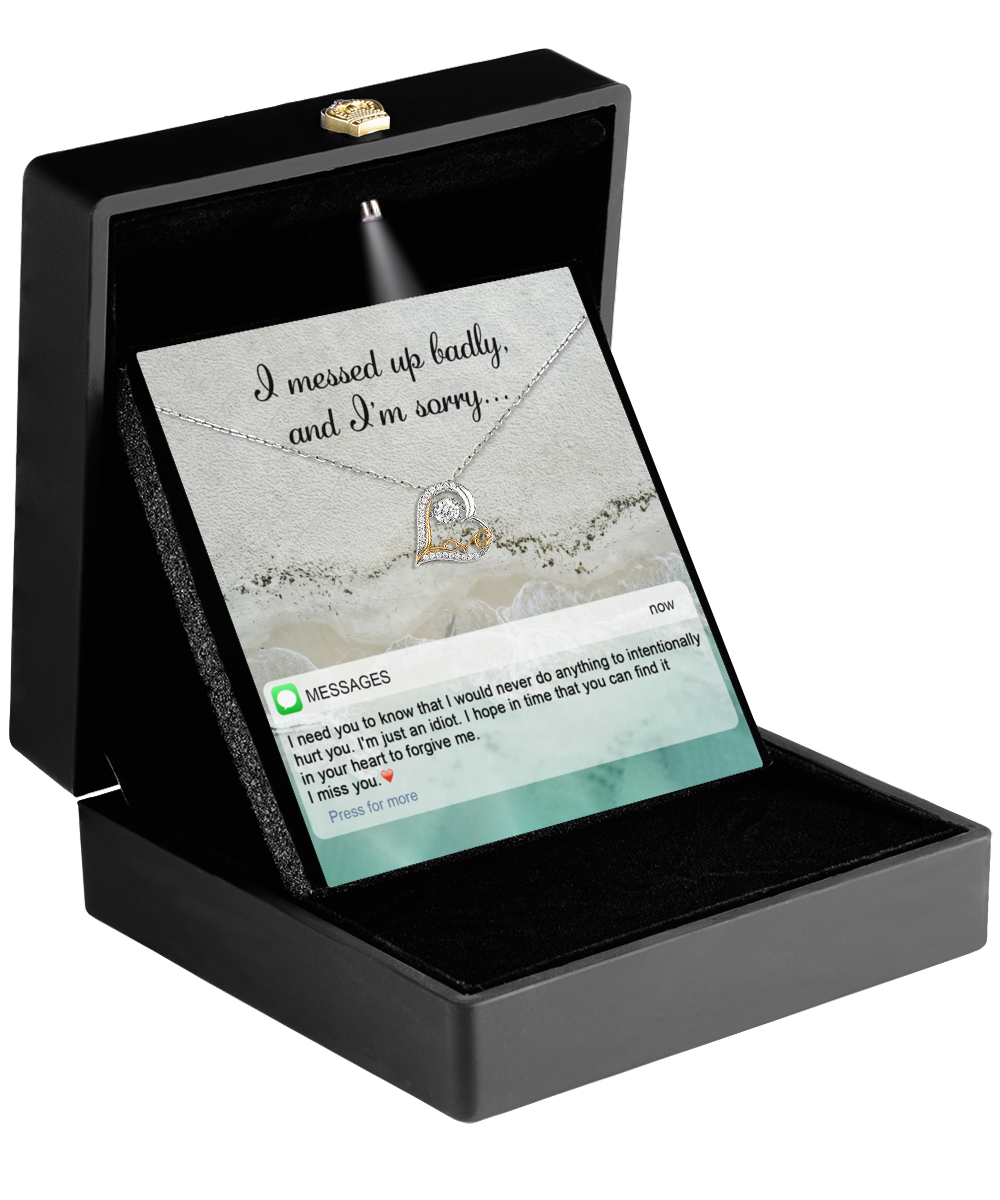 A black jewelry box holds the Sorry-Just An Idiot - Love Dancing Necklace with a heart-shaped pendant. Inside, a card reads, "I messed up badly, and I'm sorry," along with a touching message seeking forgiveness.