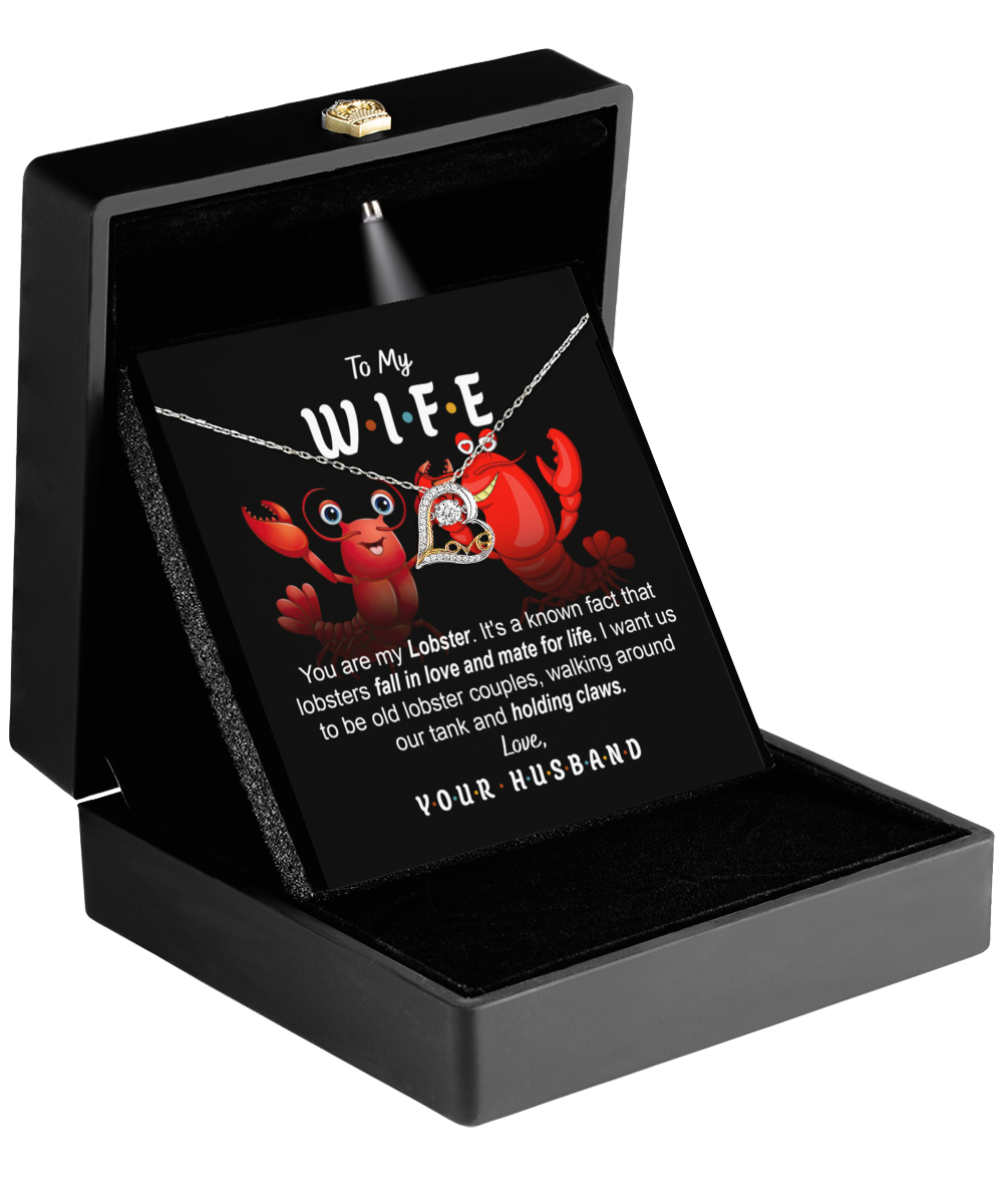 The Wife-Old Lobster Couples - Love Dancing Necklace is elegantly showcased in an open black box, accompanied by a delightful card featuring two cartoon lobsters and a touching message to a wife. This 14k gold necklace with a heart pendant is the ideal gift to express your love.