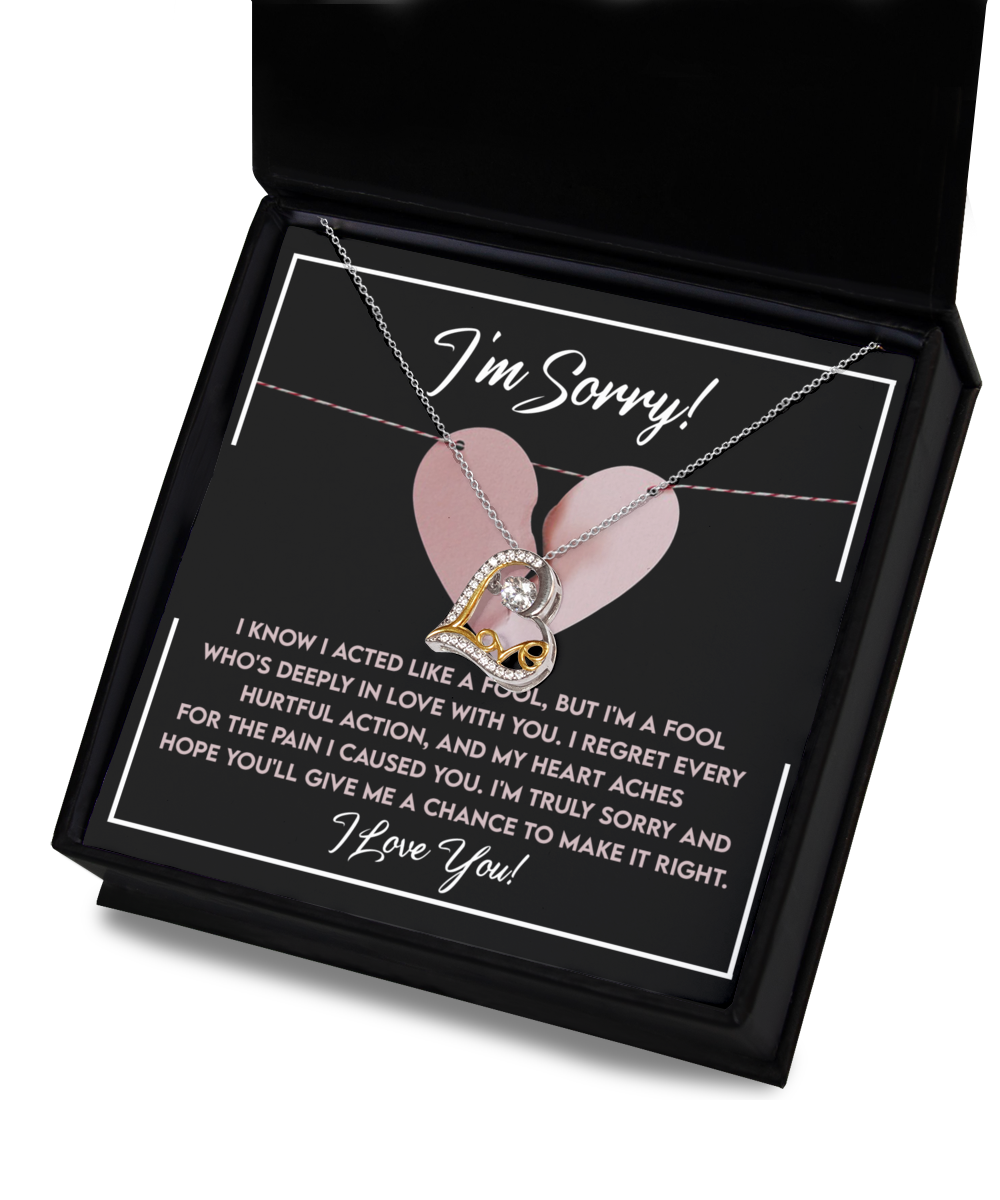 A Sorry-Deeply In Love - Love Dancing Necklace featuring intertwined heart and infinity symbols, accompanied by a rhodium triple-plated apology card that reads, "I'm Sorry! I know I acted like a fool, but I'm a fool who's deeply in love with you...".