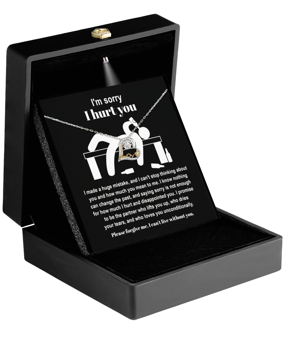 The Sorry-Change The Past 2 - Love Dancing Necklace, crafted from 14k gold, rests in a black box with its heart-shaped pendant elegantly paired with a card featuring the message "I'm sorry I hurt you" in white text on a dark background.