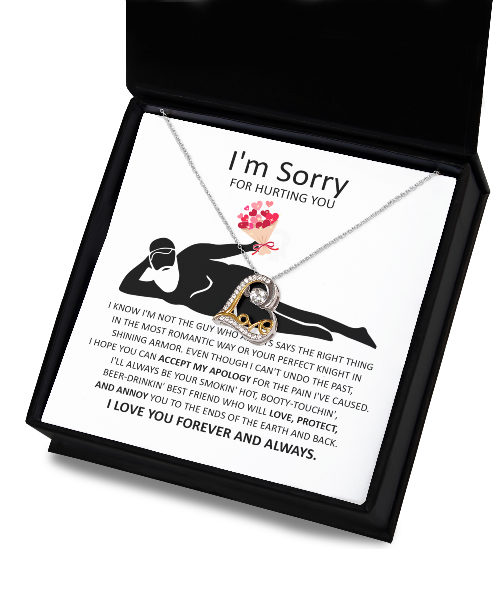 A 14k gold, heart-shaped "Love Dancing Necklace" from the "Sorry-The Most Romantic" collection is placed on a note of apology for causing hurt, featuring an illustration of a person resting and holding a bouquet, declaring everlasting love and protection.