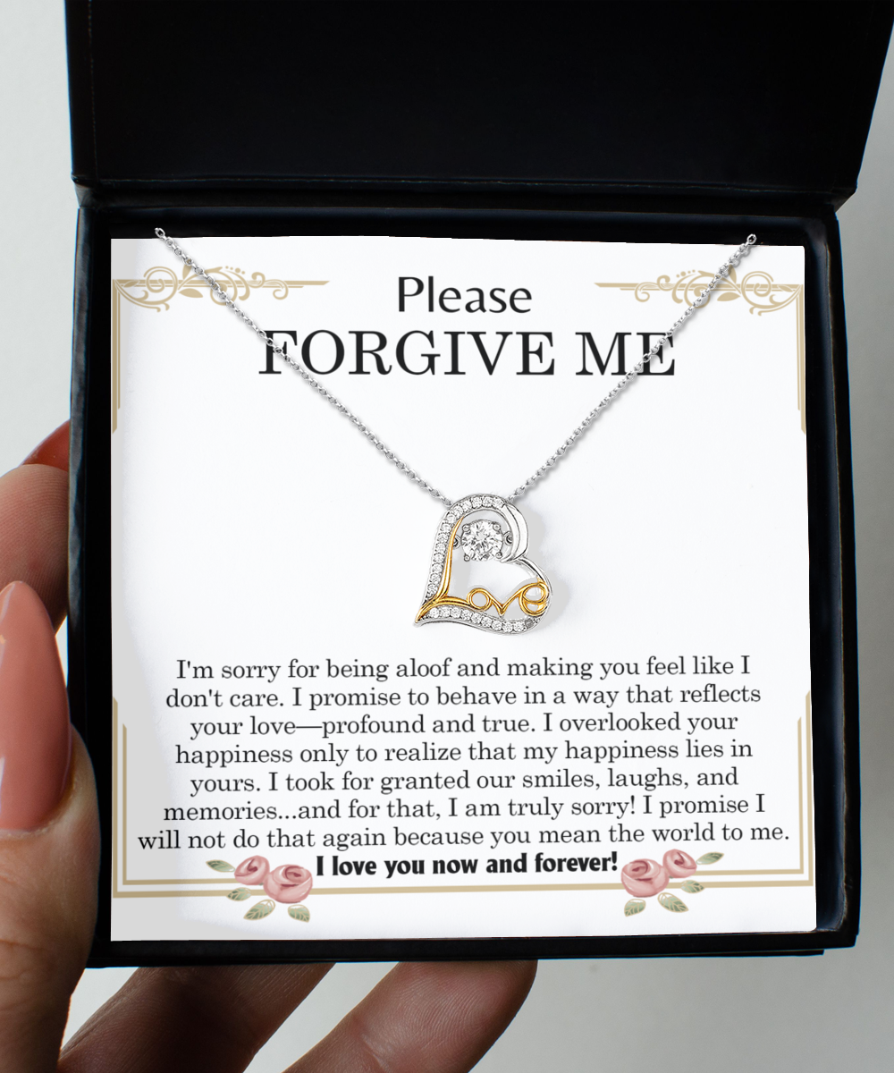 The "Sorry-Profound And True- Love Dancing Necklace," a heart-shaped pendant crafted in sterling silver, is displayed in a black box with a note that reads, "Please Forgive Me," featuring a heartfelt message of apology and love.