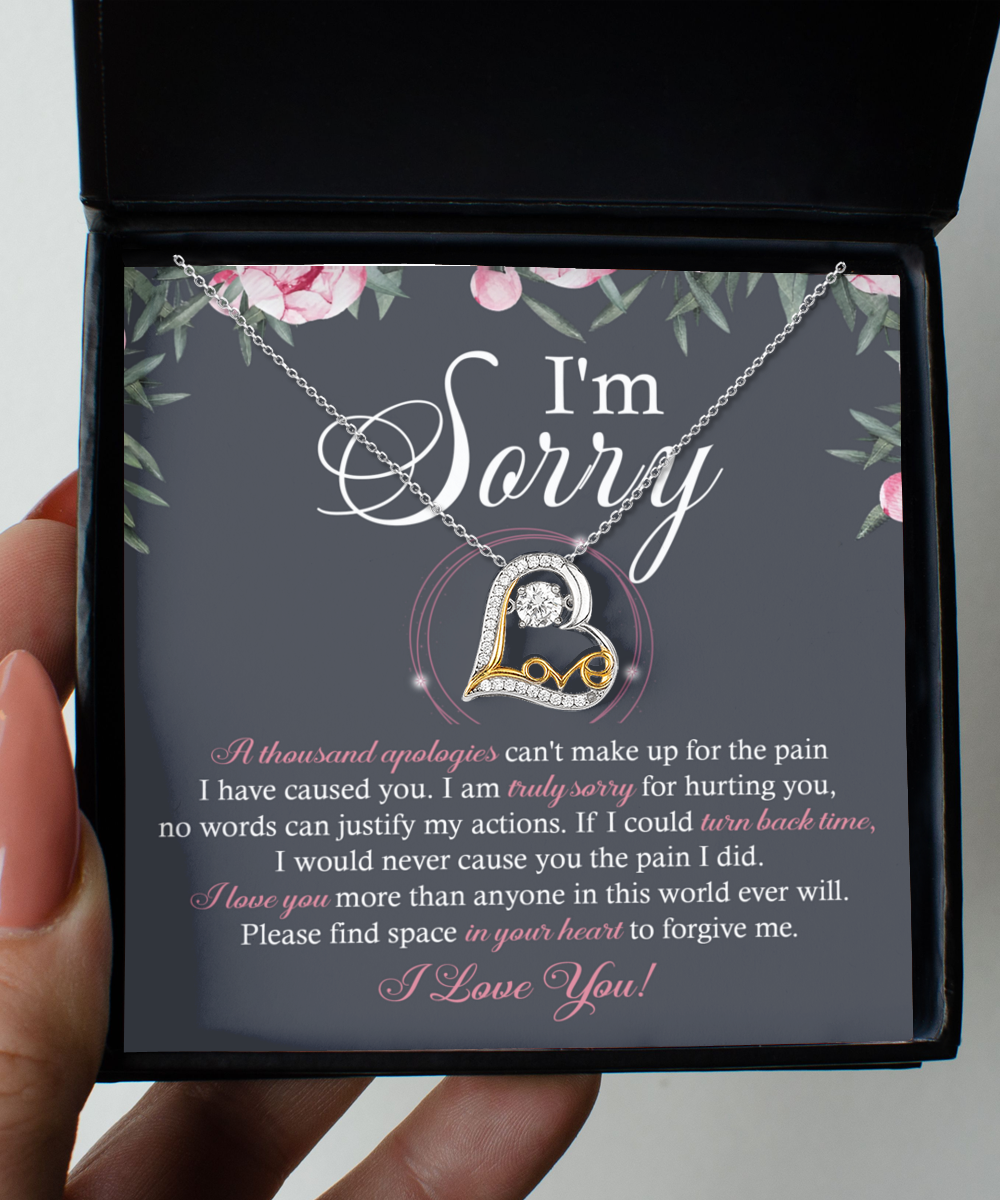 A Sorry-World Ever Will - Love Dancing Necklace, featuring a heart-shaped pendant crafted from 14k gold, rests on a card with a heartfelt apology message that reads: "I'm Sorry" and includes an extensive text expressing regret and seeking forgiveness.