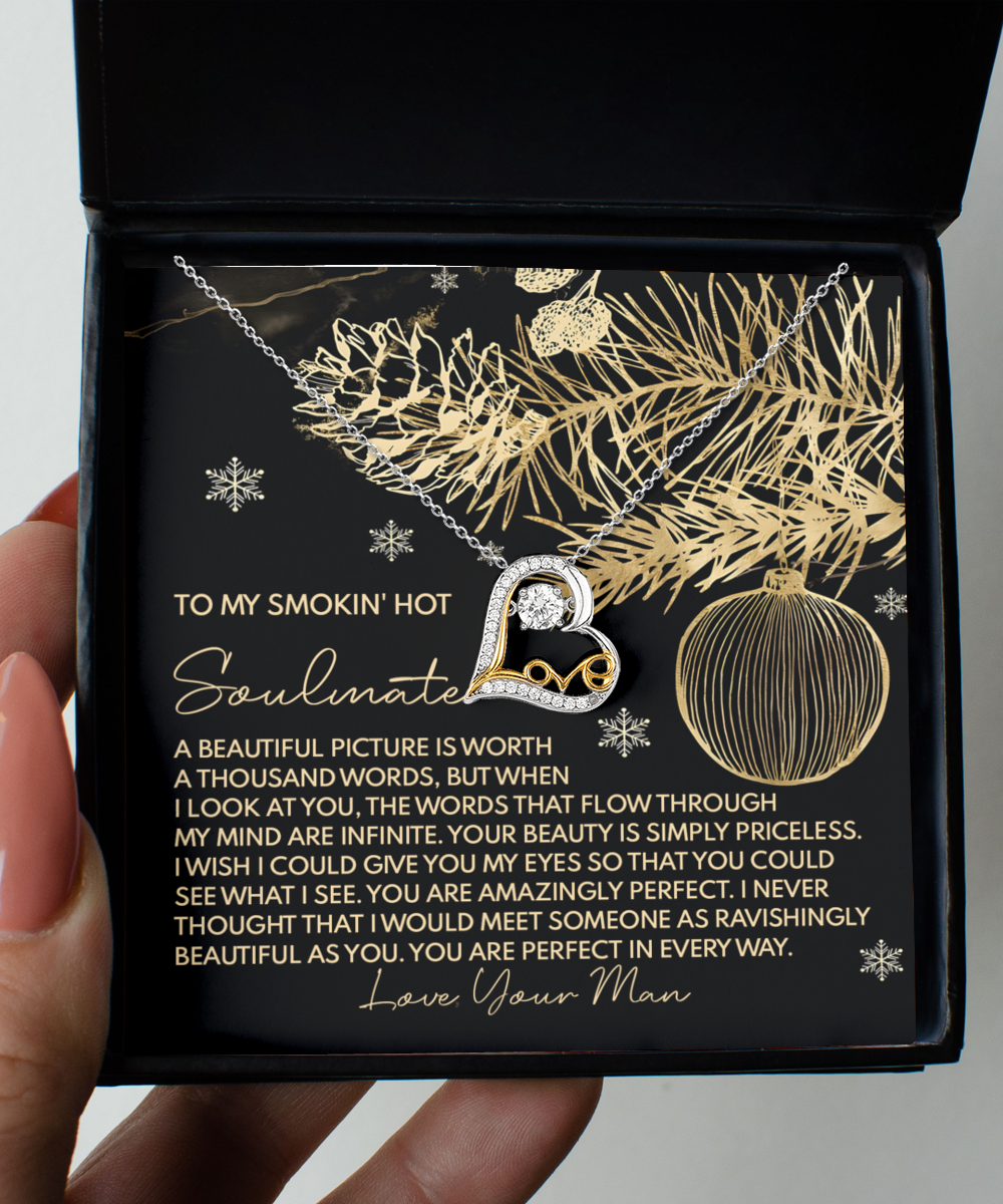 The Soulmate-Amazingly Perfect - Love Dancing Necklace is a sterling silver heart-shaped piece with a 14k gold infinity symbol, beautifully showcased in an open gift box. It comes with a heartfelt message on a black card decorated with golden pine and ornament design, making it the perfect expression of affection.