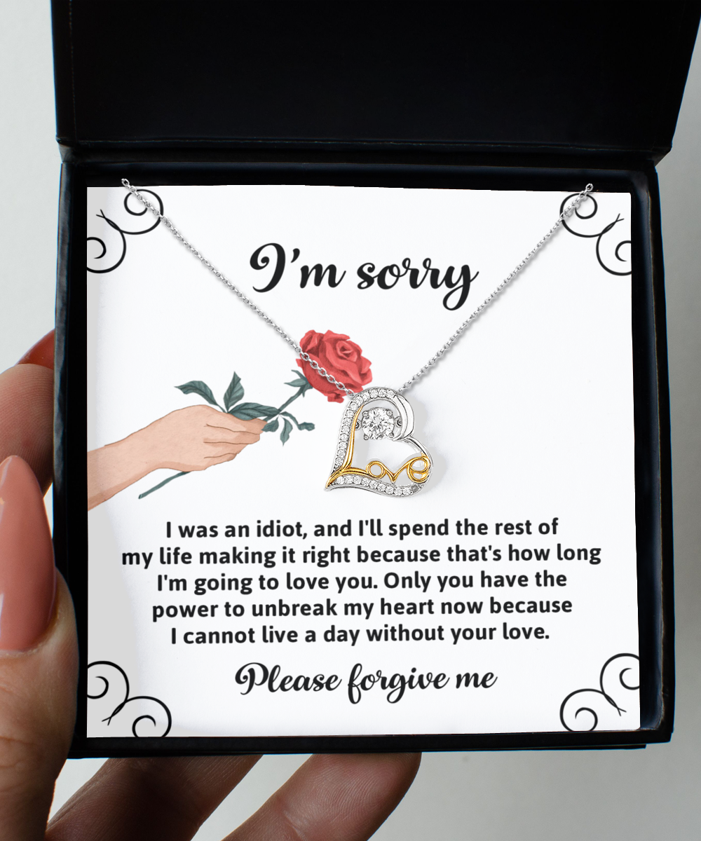 A Sorry-Making It Right - Love Dancing Necklace, featuring a red rose and heart-shaped design crafted in 14k gold, is displayed above an apology note with the text: "I'm sorry. Please forgive me.