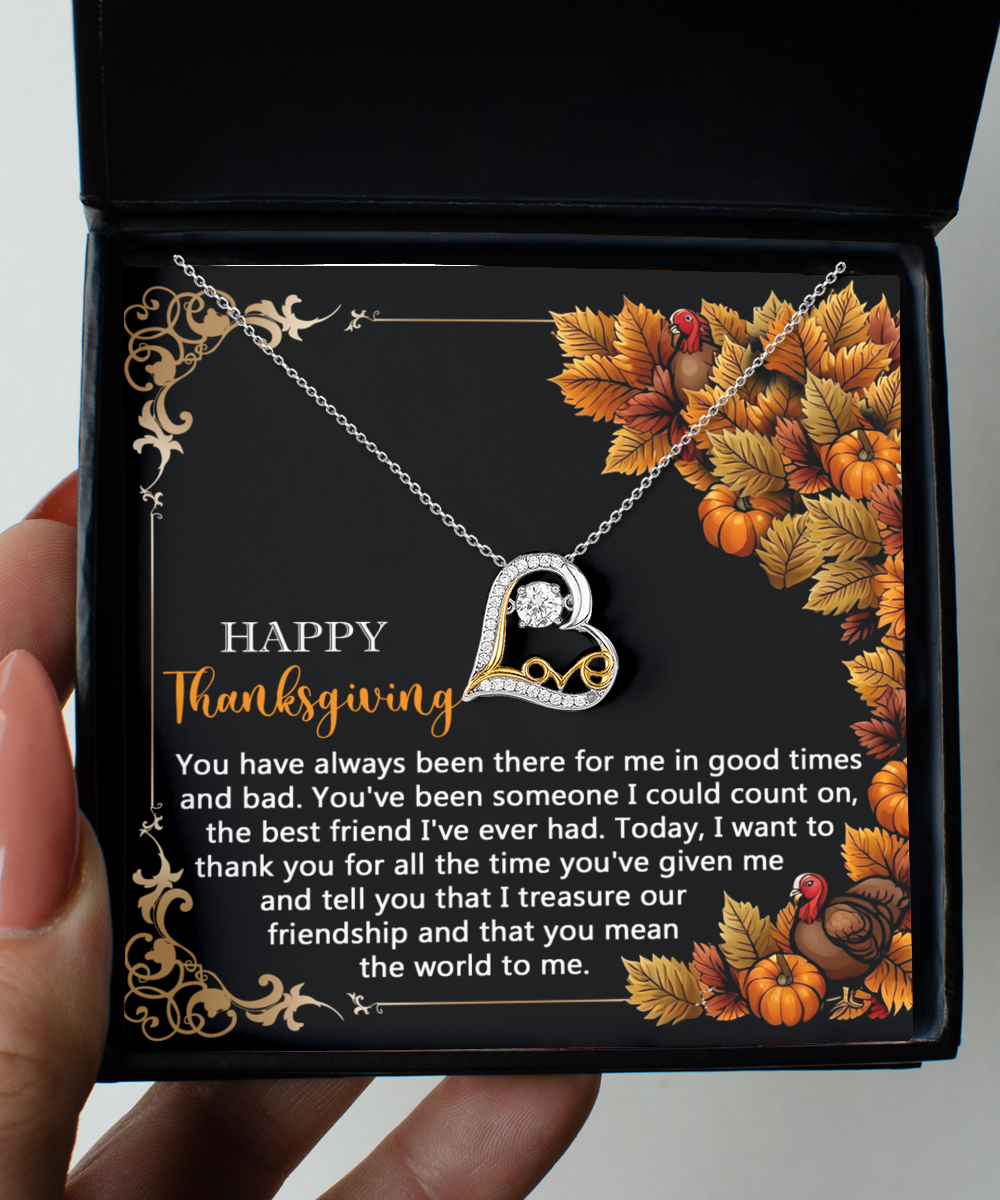 The Thanksgiving-Count On - Love Dancing Necklace, featuring a sterling silver heart pendant, is beautifully displayed in a box. The backdrop includes autumn leaves and pumpkins, accompanied by a Thanksgiving message conveying gratitude for friendship.