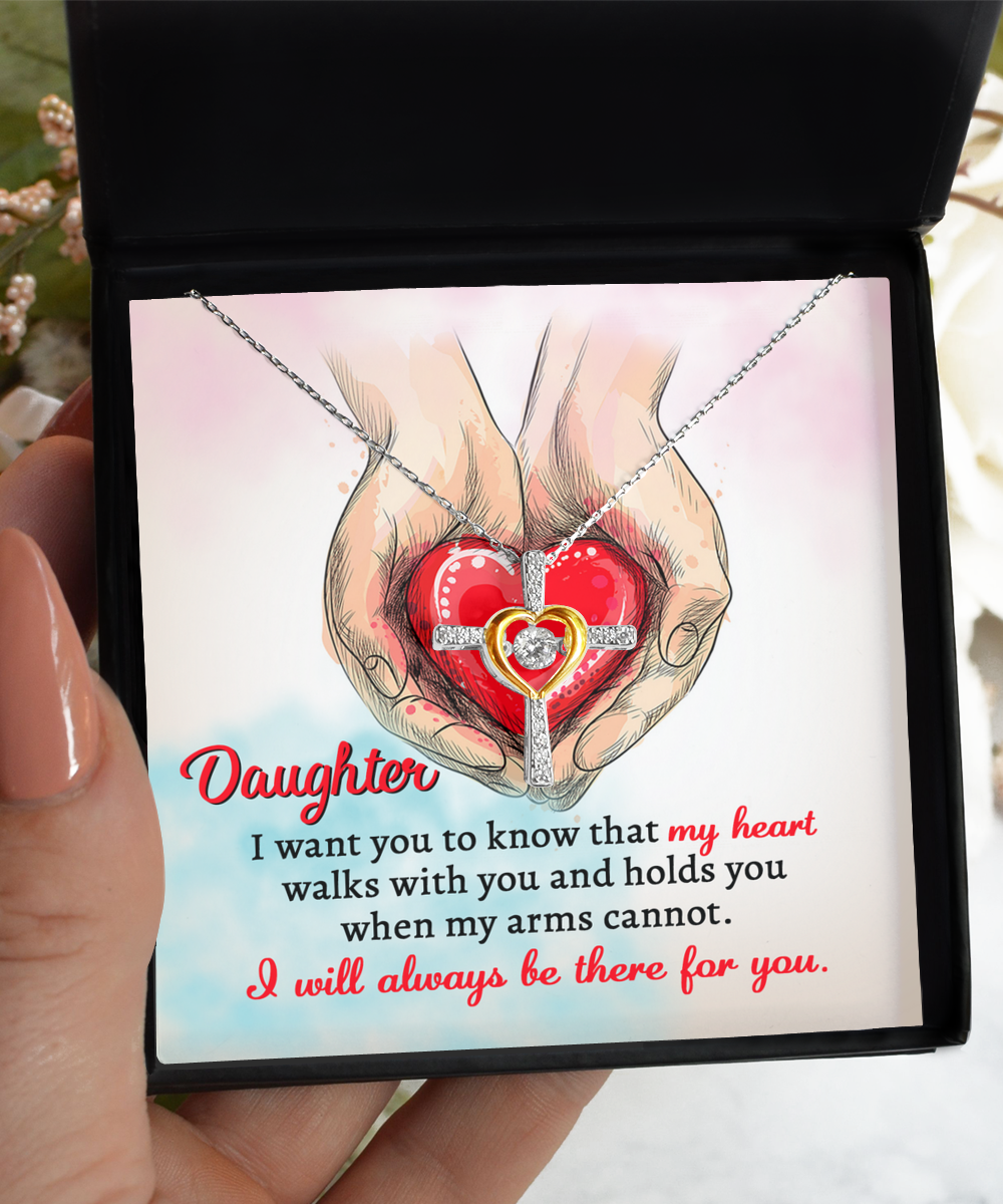 A Daughter-Always Be There - Cross Dancing Necklace inside a box with an illustration of hands holding a heart. Text reads: "Daughter, I want you to know that my heart walks with you and holds you when my arms cannot. I will always be there for you.