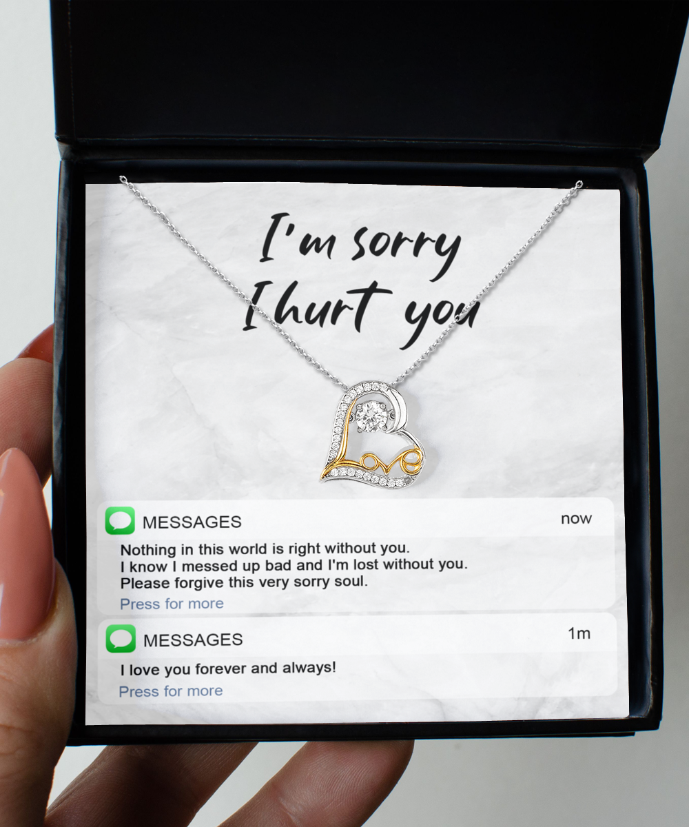 The Sorry-Lost Without You - Love Dancing Necklace, a 14k gold plated necklace featuring a double heart pendant, is elegantly presented in a box with the heartfelt message, "I'm sorry I hurt you," accompanied by two text message notifications below conveying regret and love.