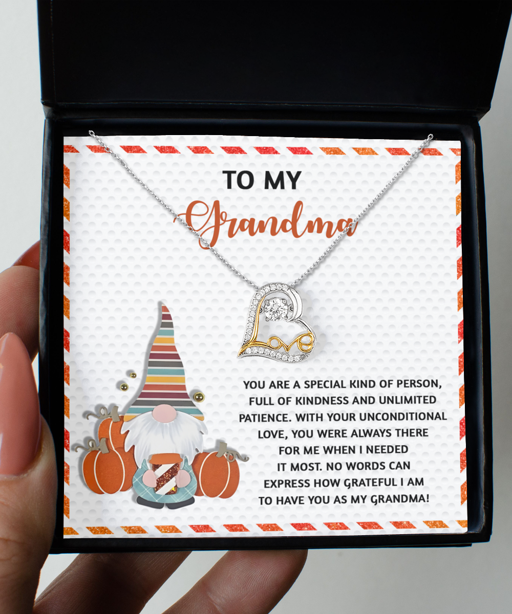 The Grandma-Needed It Most - Love Dancing Necklace showcases a heart pendant elegantly crafted in 14k Gold. Presented in a delightful box, the card says "To my Grandma," with a touching message and a cute gnome illustration.