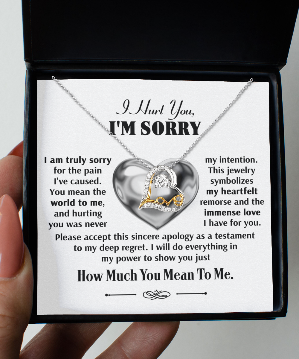 A hand holds a jewelry box containing the Sorry-Sincere Apology - Love Dancing Necklace, a sterling silver necklace with a heart pendant and an apology note expressing remorse and love.