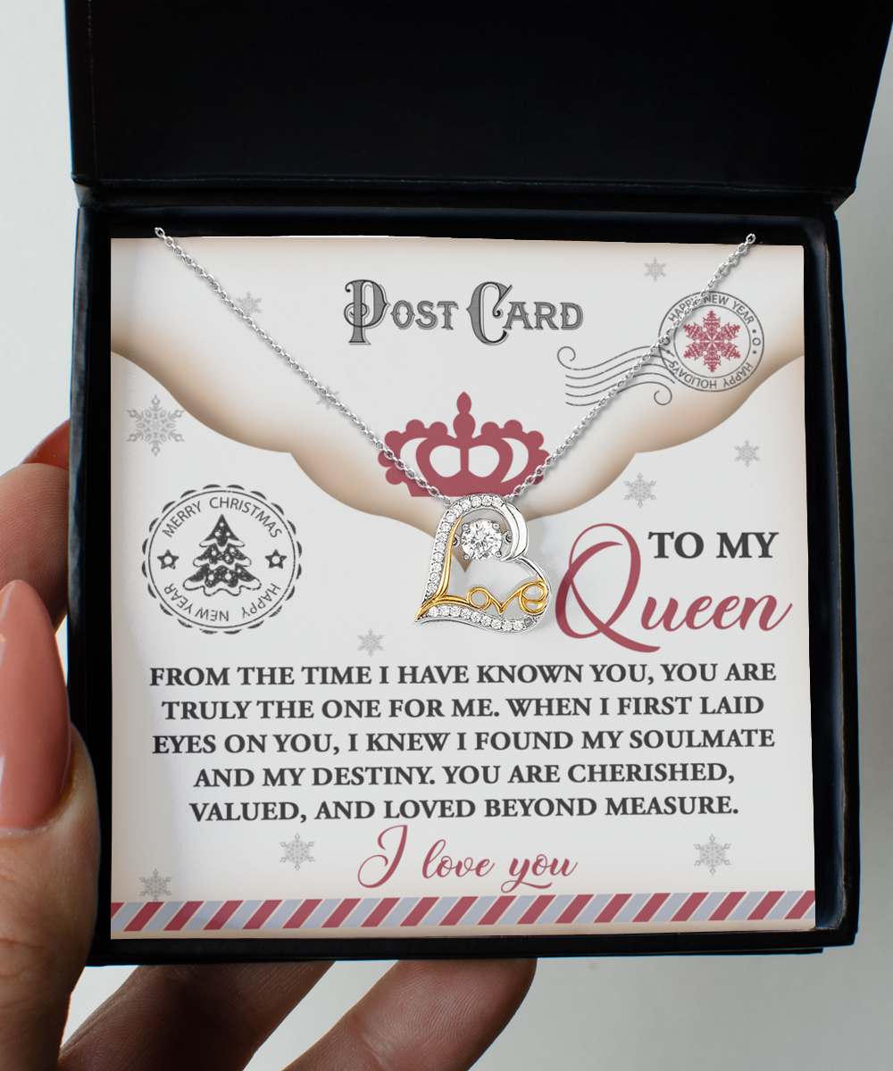 A hand holds an open box containing the Soulmate-The One - Love Dancing Necklace featuring a heart pendant. Crafted in 14k Gold, the box includes a card with the words "To my Queen" and a heartfelt message, making this gift truly special.