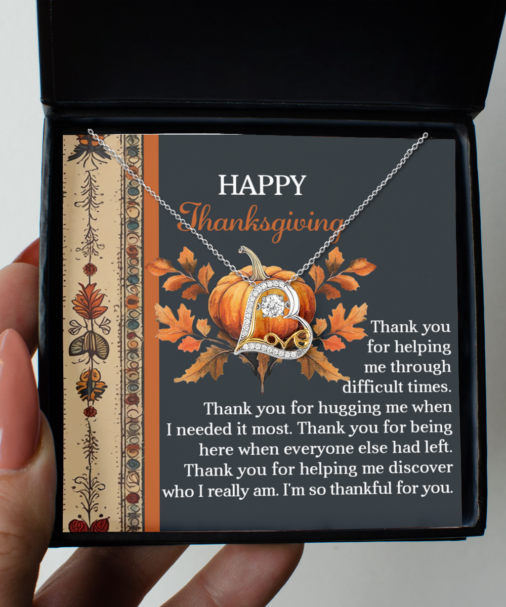 A hand presents an open necklace box featuring a "Happy Thanksgiving" message alongside a stylish Sterling Silver "L" necklace and a heartfelt note of gratitude underneath. The Thanksgiving-I Really Am - Love Dancing Necklace shines warmly, making it the ideal 14k gold gift for conveying thanks and love.