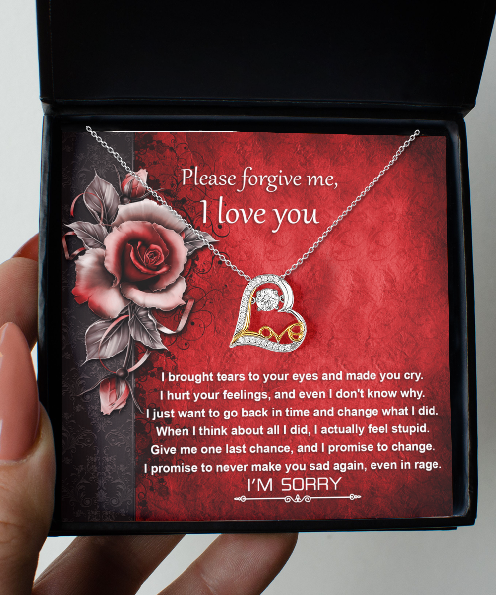 The Sorry-One Last Chance - Love Dancing Necklace, a 14k gold necklace featuring a heart pendant, is beautifully displayed above a heartfelt message reading "Please forgive me, I love you," set against a vibrant red floral background.