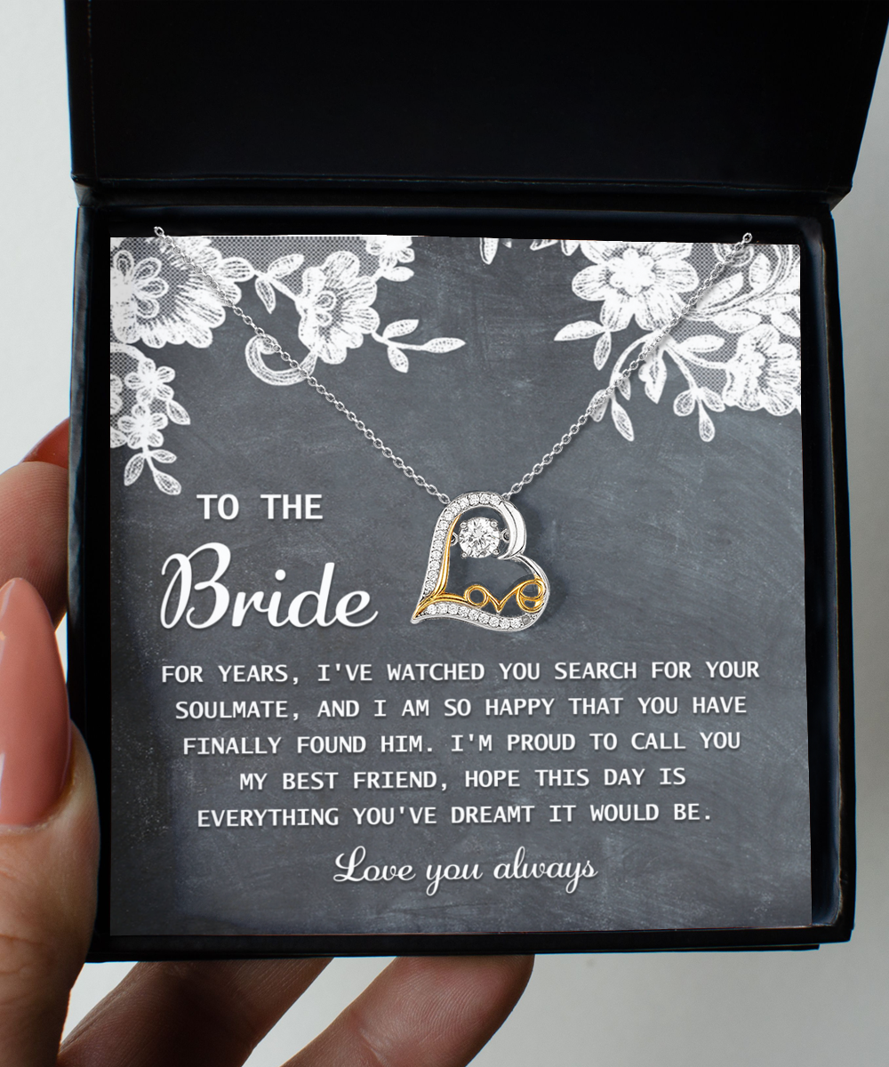 A heart-shaped 14k gold "To Bride-My Best Friend - Love Dancing Necklace" rests atop a card with a message to the bride, expressing joy for finding her soulmate and wishing the day to be everything she dreamed of.