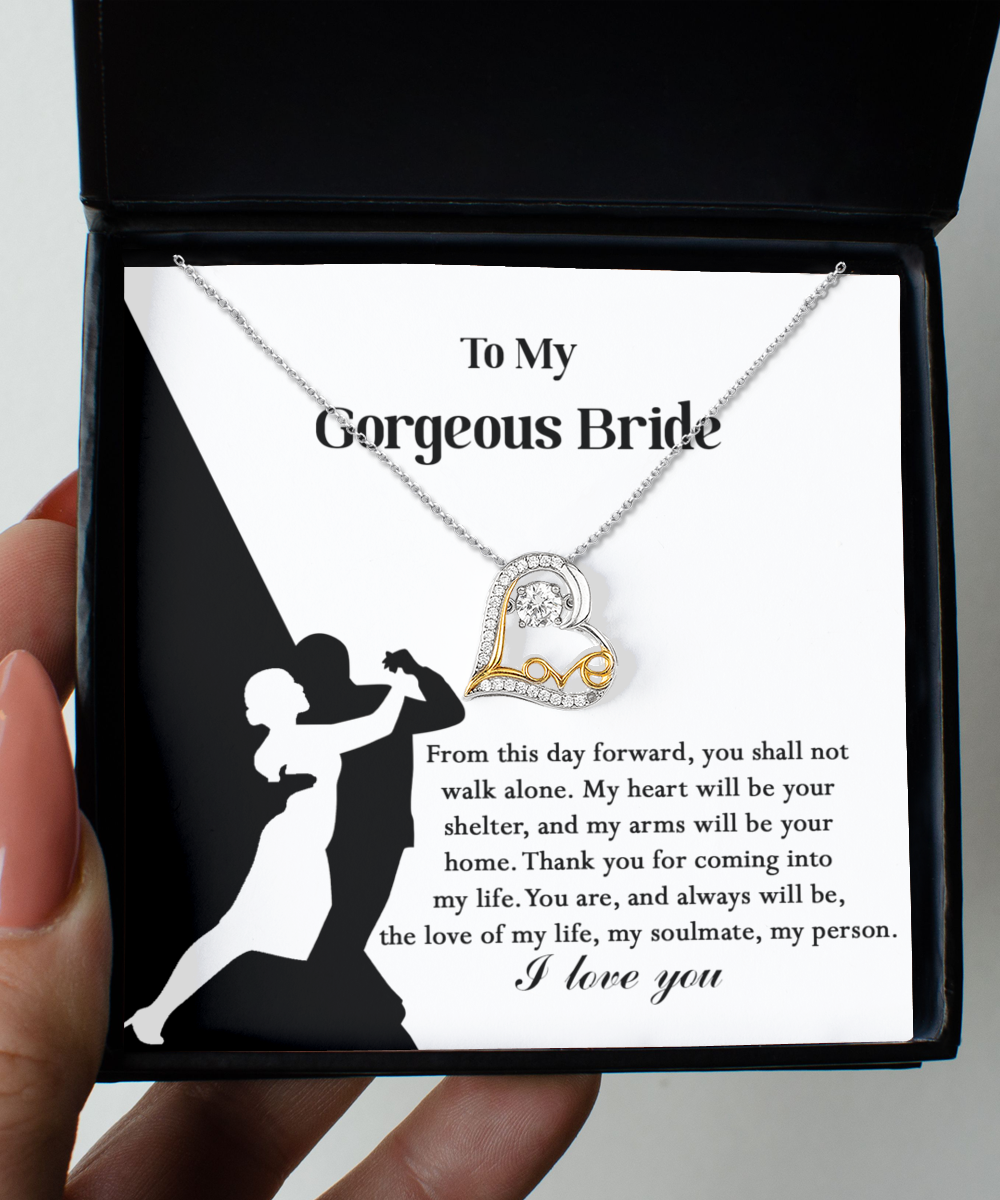 A Bride-Be Your Home - Love Dancing Necklace with a heart pendant, crafted in 14k gold plated, is displayed on a card featuring a silhouette of a dancing couple and a message addressing "My Gorgeous Bride," expressing love and commitment.