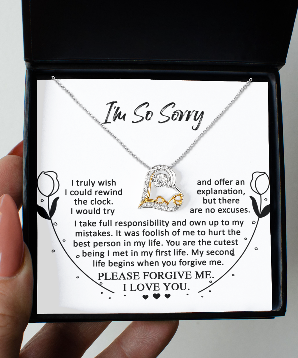 A hand holds an open box containing a heart-shaped, 14k gold "Sorry-My First Life - Love Dancing Necklace" along with a heartfelt apology message expressing regret, asking for forgiveness, and declaring love.