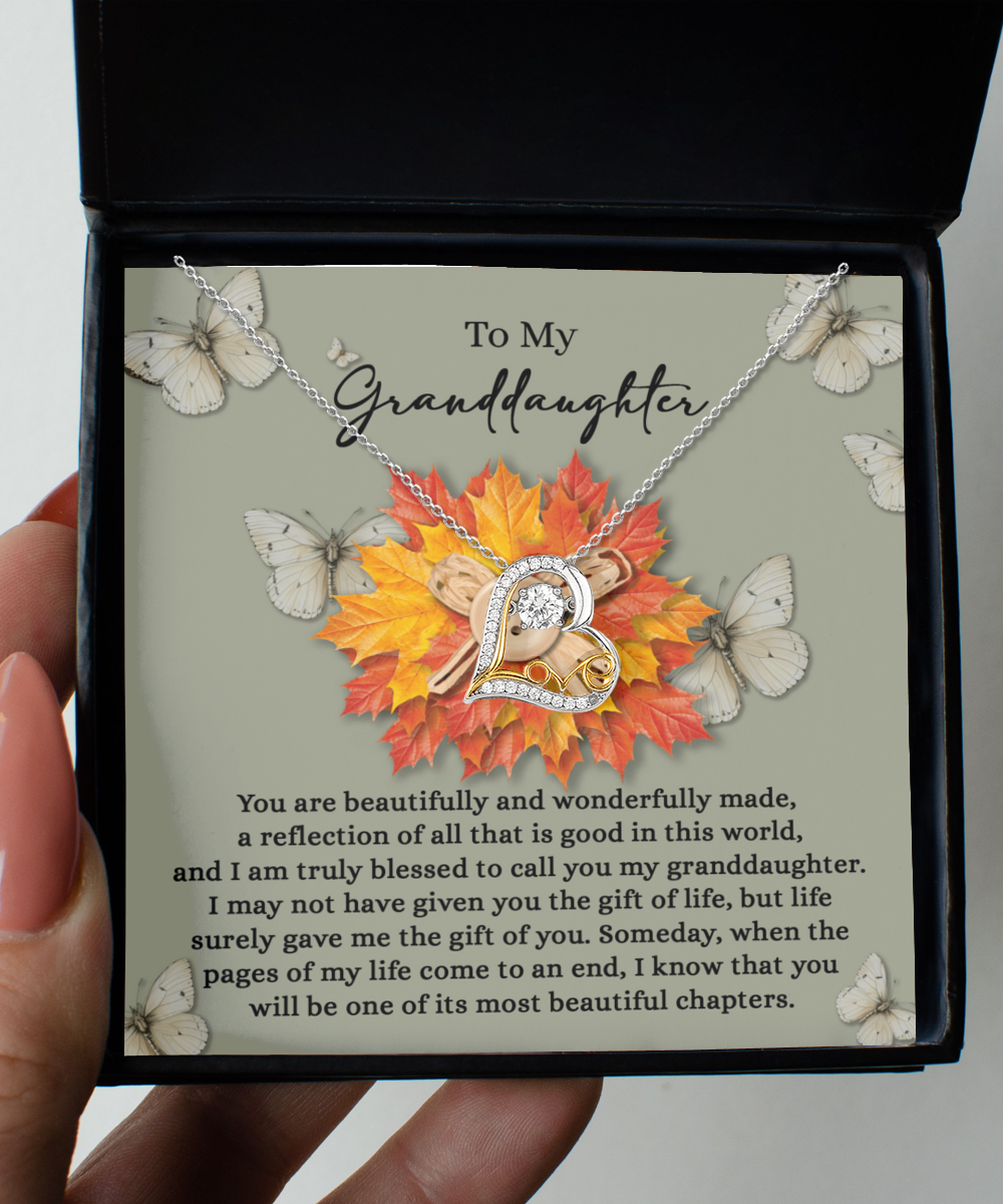 The "Granddaughter-Gift Of You - Love Dancing Necklace," a sterling silver piece featuring a heart pendant, is beautifully presented in a gift box adorned with butterflies, autumn leaves, and the message "To My Granddaughter.