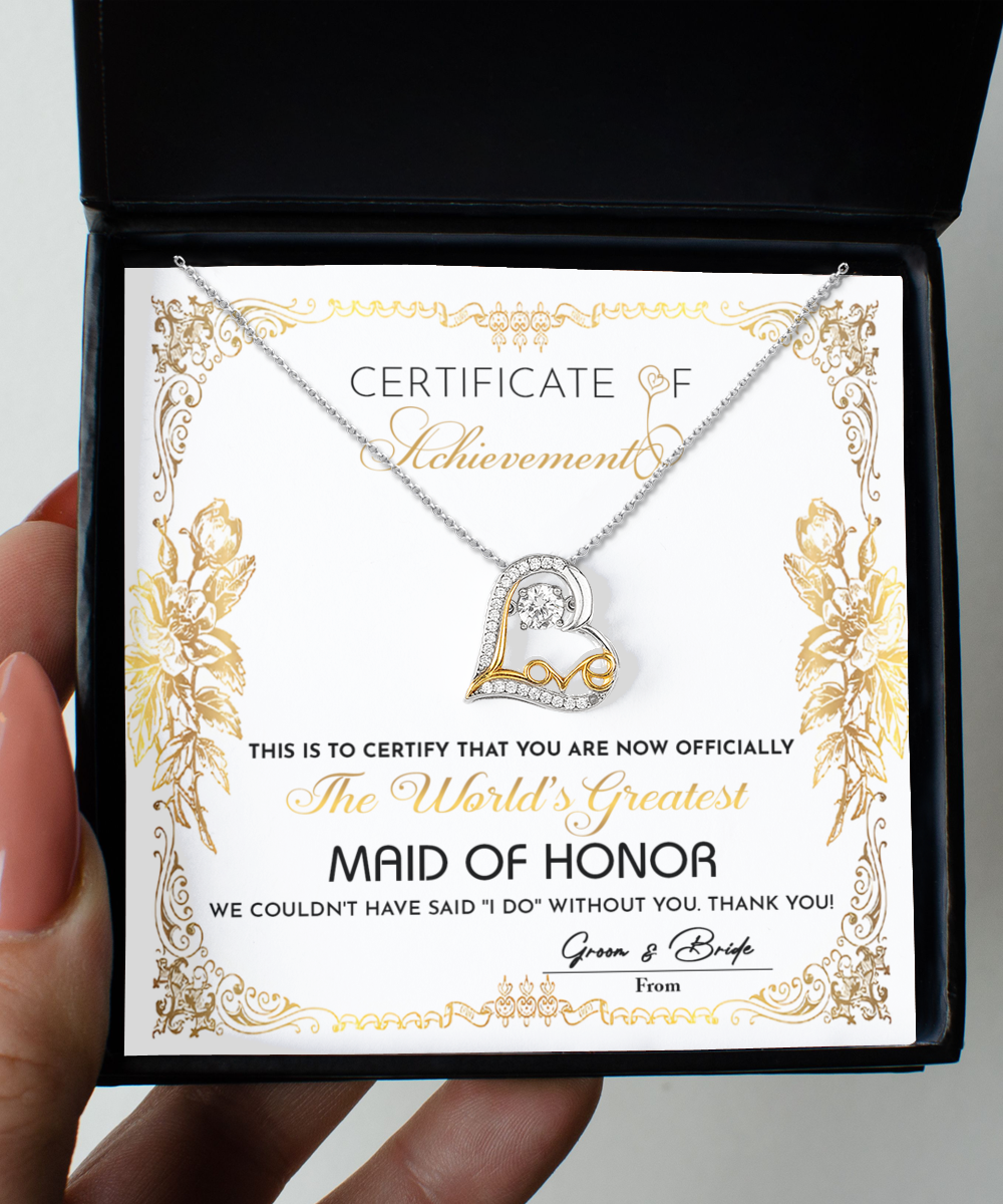 A "To Maid Of Honor-Certificate Of Achievement" titled "The World's Greatest Maid of Honor" in an ornate design, complemented by a heart-shaped Love Dancing Necklace in .925 Sterling Silver placed over it.