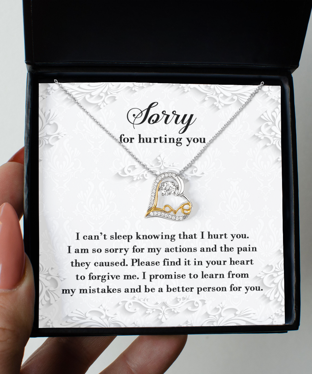 A 14k gold "Sorry-Can't Sleep - Love Dancing Necklace" in an open box with a heartfelt message of apology, expressing regret for causing pain and a promise to learn from mistakes. The text is elegantly displayed on a decorative background.