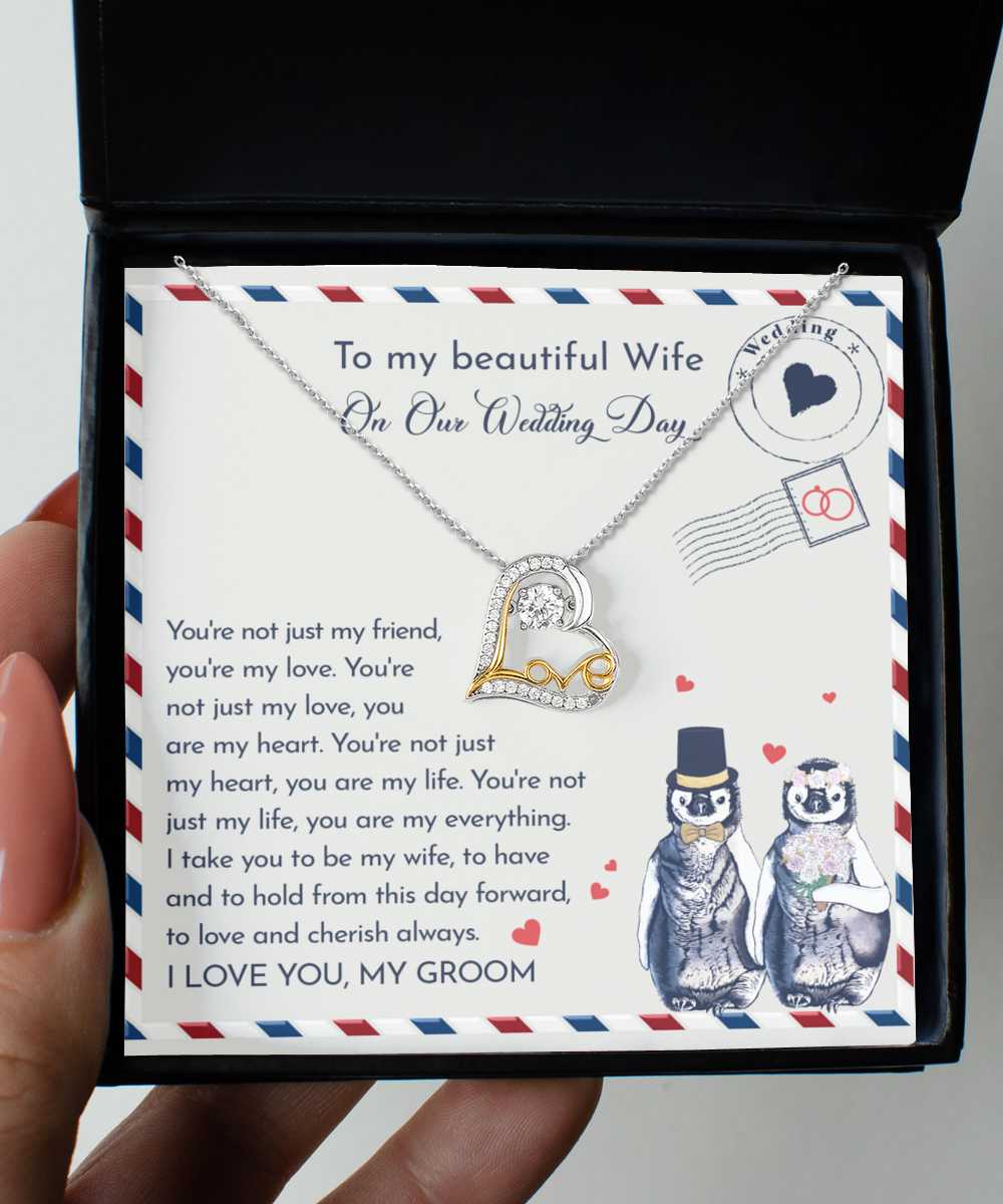 A To Wife Wedding, Love And Cherish - Love Dancing Necklace with a heart-shaped pendant in .925 Sterling Silver, presented in a box featuring a heartfelt message to a wife on their wedding day, accompanied by an illustration of two penguins dressed as bride and groom.