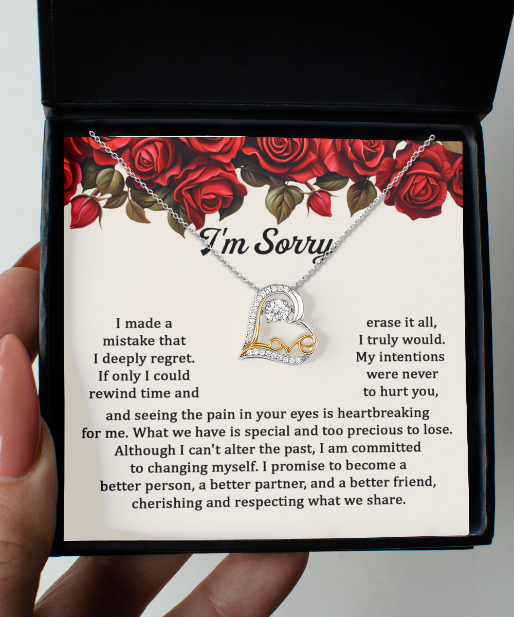 The Sorry-Precious To Lose - Love Dancing Necklace, a 14k gold plated piece with a heart-shaped pendant, is showcased on a note that bears an apology message and is adorned with red roses.