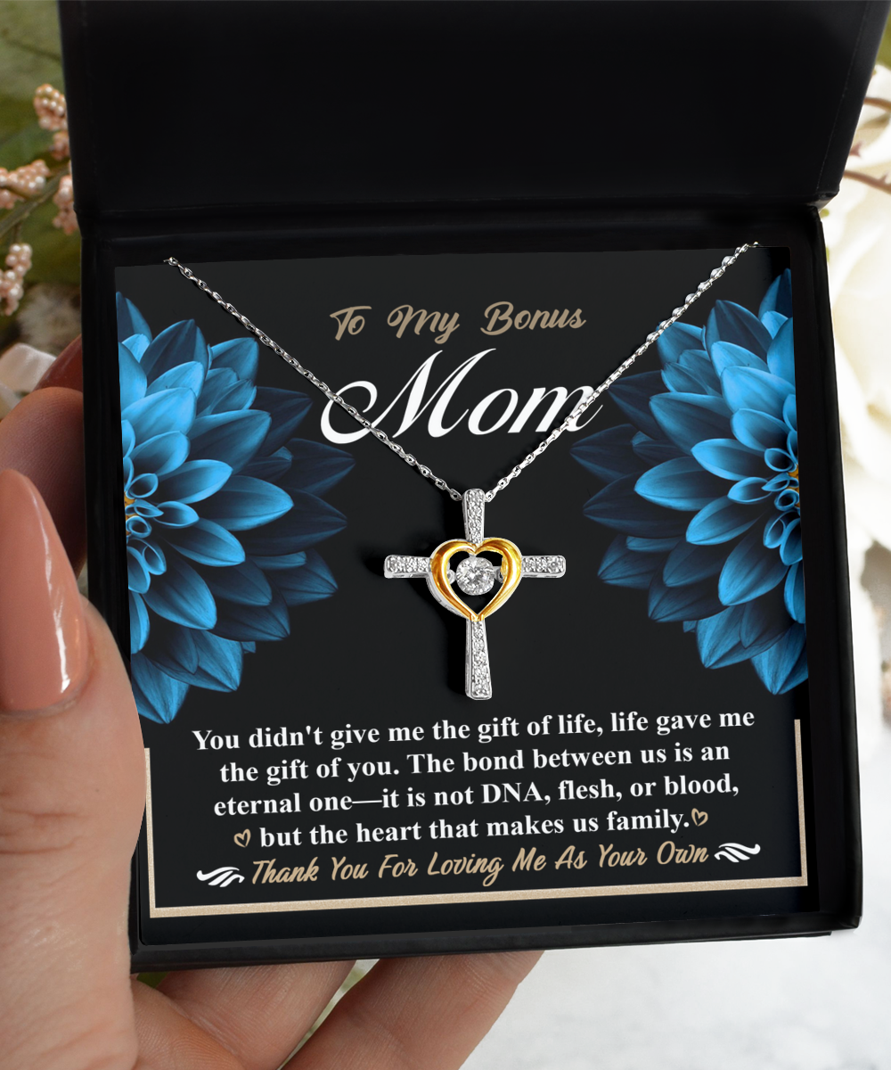 A hand holding an open gift box with a To Bonus Mom, Gift Of You - Cross Dancing Necklace from Gearbubble, alongside a heartfelt message for a stepmother, symbolizing mother's love.