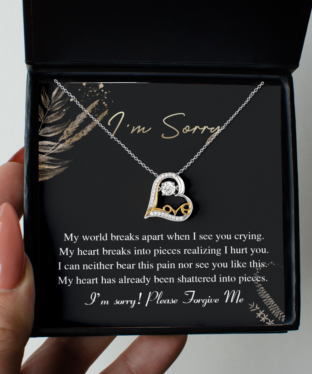 The Sorry-See You Crying - Love Dancing Necklace is a 14k gold triple-plated necklace featuring a heart-shaped pendant, elegantly displayed in an open gift box. The inner lid of the box reads, "I'm Sorry," accompanied by an apologetic message beneath.