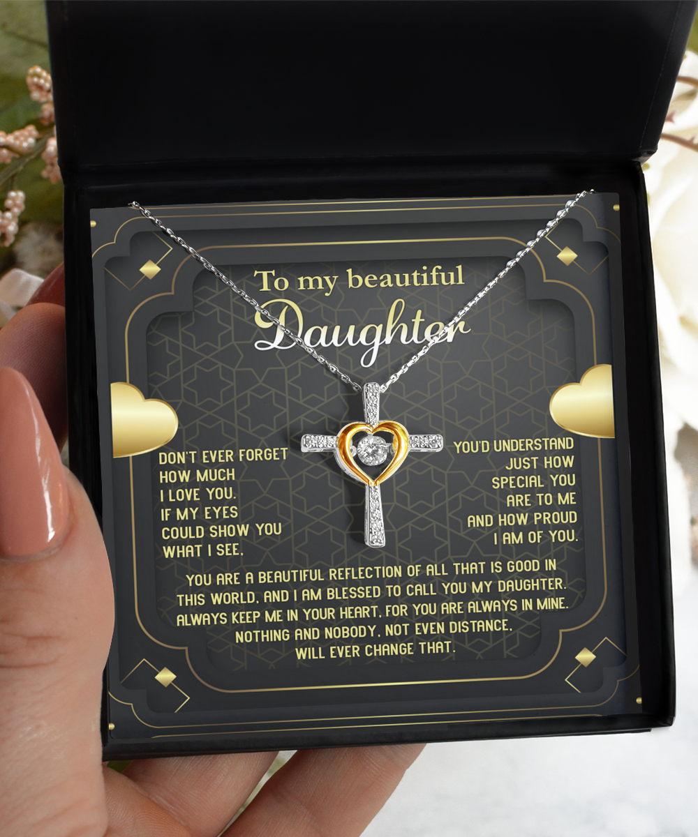 A hand is holding an open gift box containing a .925 Sterling Silver "To Daughter-Beautiful Reflection - Cross Dancing Necklace" with interlocking heart and cross pendants. The inside of the box lid has a heartfelt message addressed "To my beautiful Daughter," expressing love, pride, and the unchanging bond between parent and child.