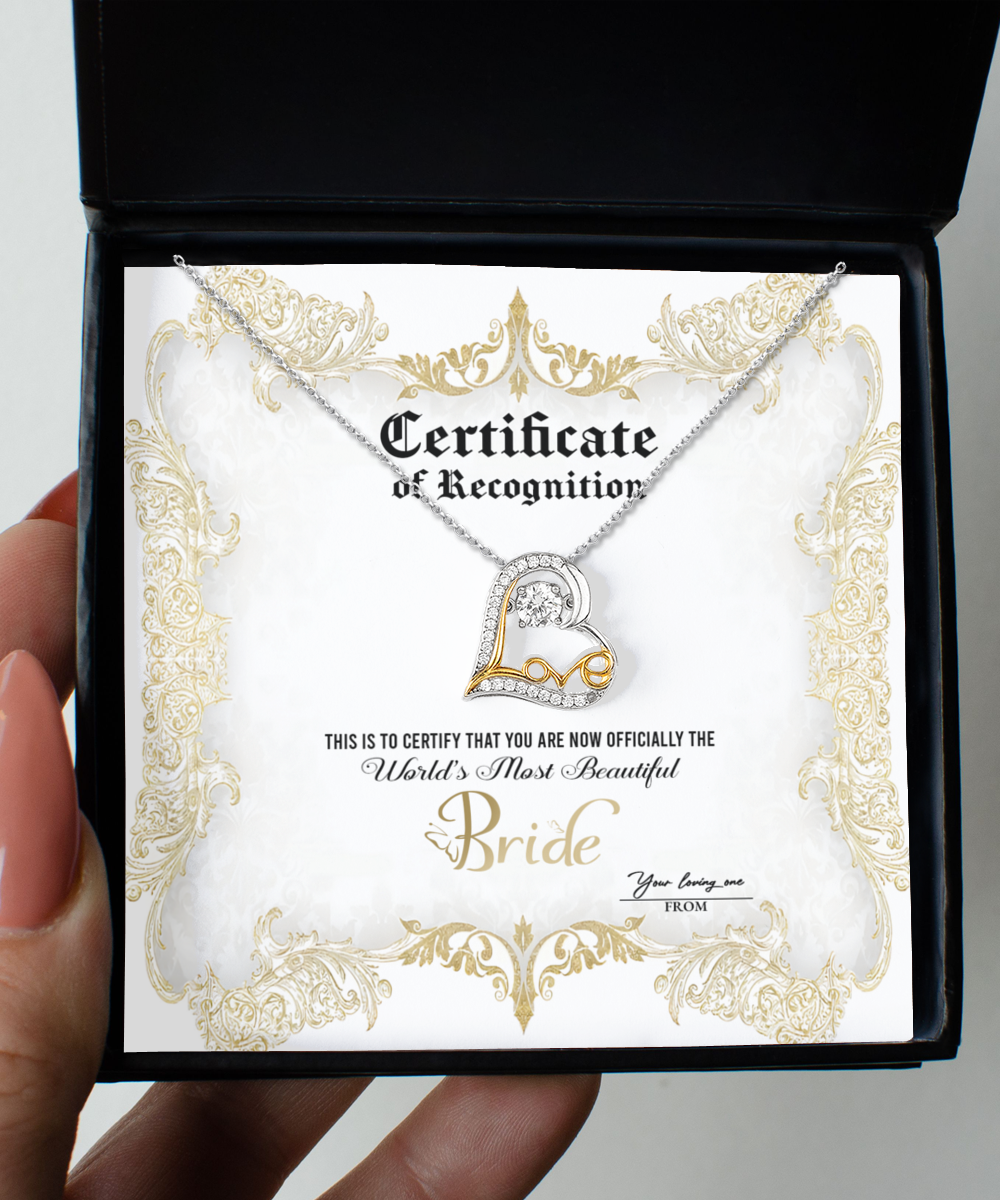 An open black box containing a Bride-Certificate Of Achievement - Love Dancing Necklace and a certificate. The certificate reads, "Certificate of Recognition. World's Most Beautiful Bride," and has a gold decorative border.