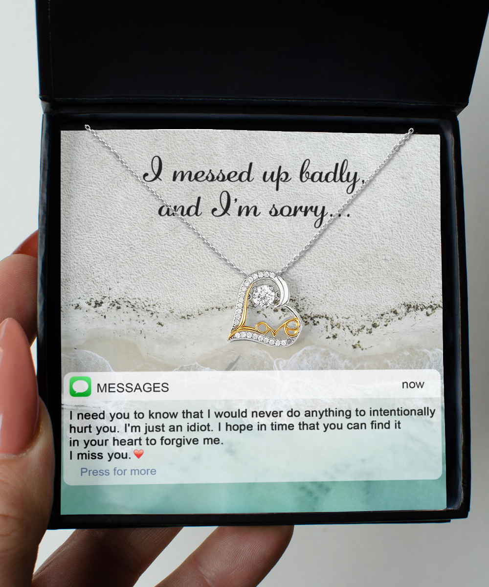 A jewelry gift box containing the "Sorry-Just An Idiot - Love Dancing Necklace," a 14k gold plated heart-shaped necklace, along with a heartfelt message reading "I messed up badly, and I'm sorry," and a text message expressing regret and requesting forgiveness.