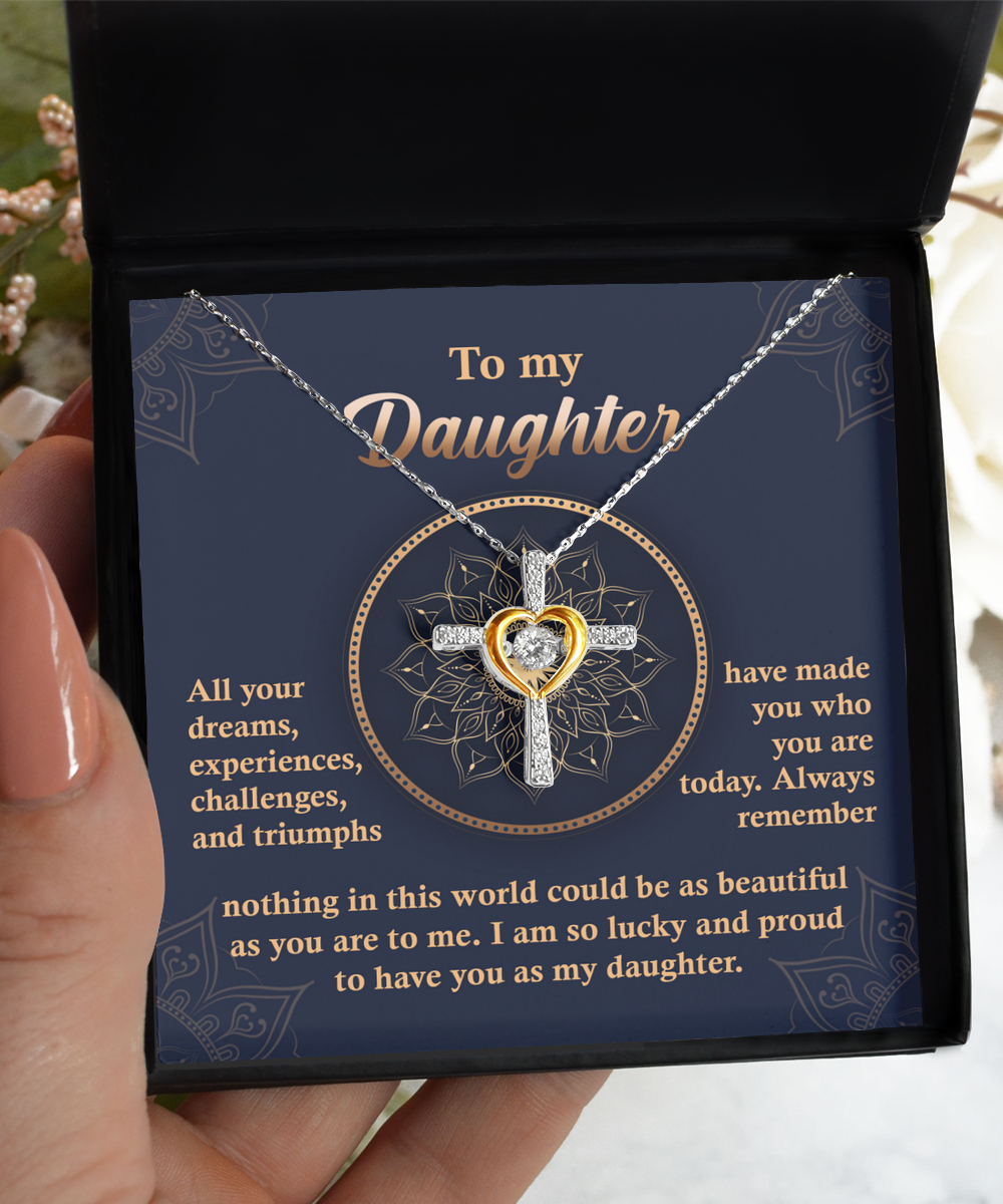 A Daughter-All Your Dreams - Cross Dancing Necklace with a heart-shaped centerpiece is displayed in an open box. The message on the box is addressed to a daughter, expressing pride and love.