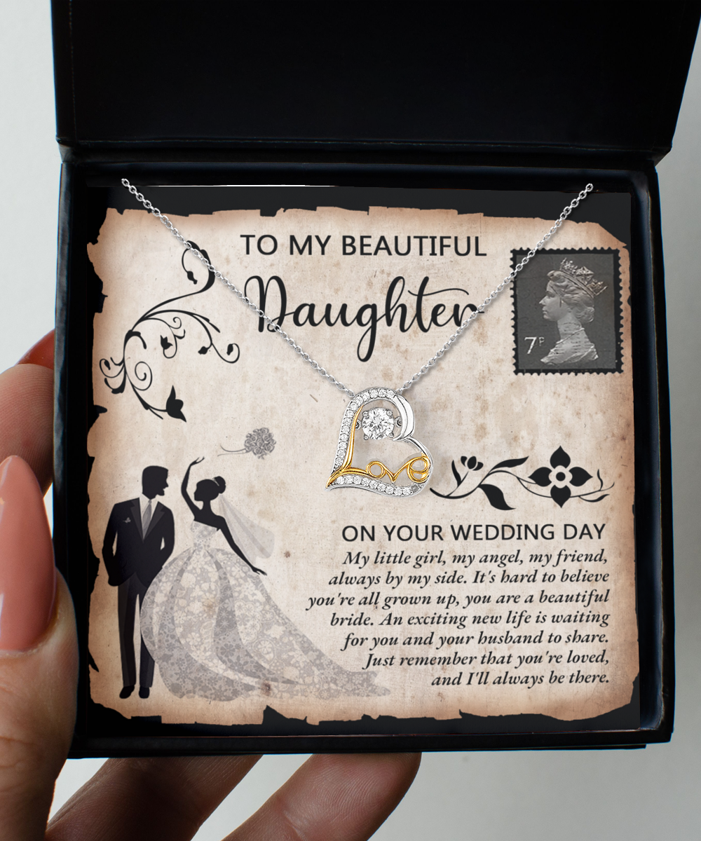 A Daughter Wedding-Beautiful Bride - Love Dancing Necklace featuring a heart-shaped pendant sits elegantly in a gift box with a heartfelt message for a daughter on her wedding day. Crafted from 14k gold, the necklace is accompanied by an illustration of a bride and groom within a decorative border.