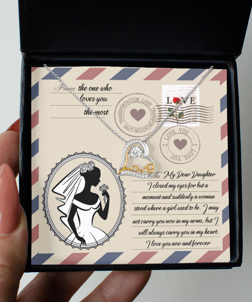 A Daughter Wedding-In My Arms - Love Dancing Necklace is displayed in a box with a decorative card. The card features a silhouette of a bride, stamps, and a heartfelt message to a daughter from a parent.