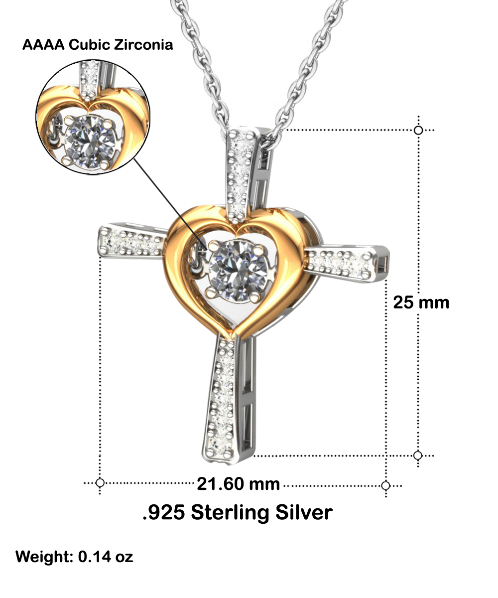 The "To Daughter-Be Proud Of - Cross Dancing Necklace" features a cubic zirconia gemstone set within a heart-shaped gold accent, surrounded by a rhodium-plated silver cross adorned with smaller cubic zirconia stones. The necklace measures 25 mm in height and 21.60 mm in width, is crafted from .925 sterling silver, and weighs 0.14 oz.