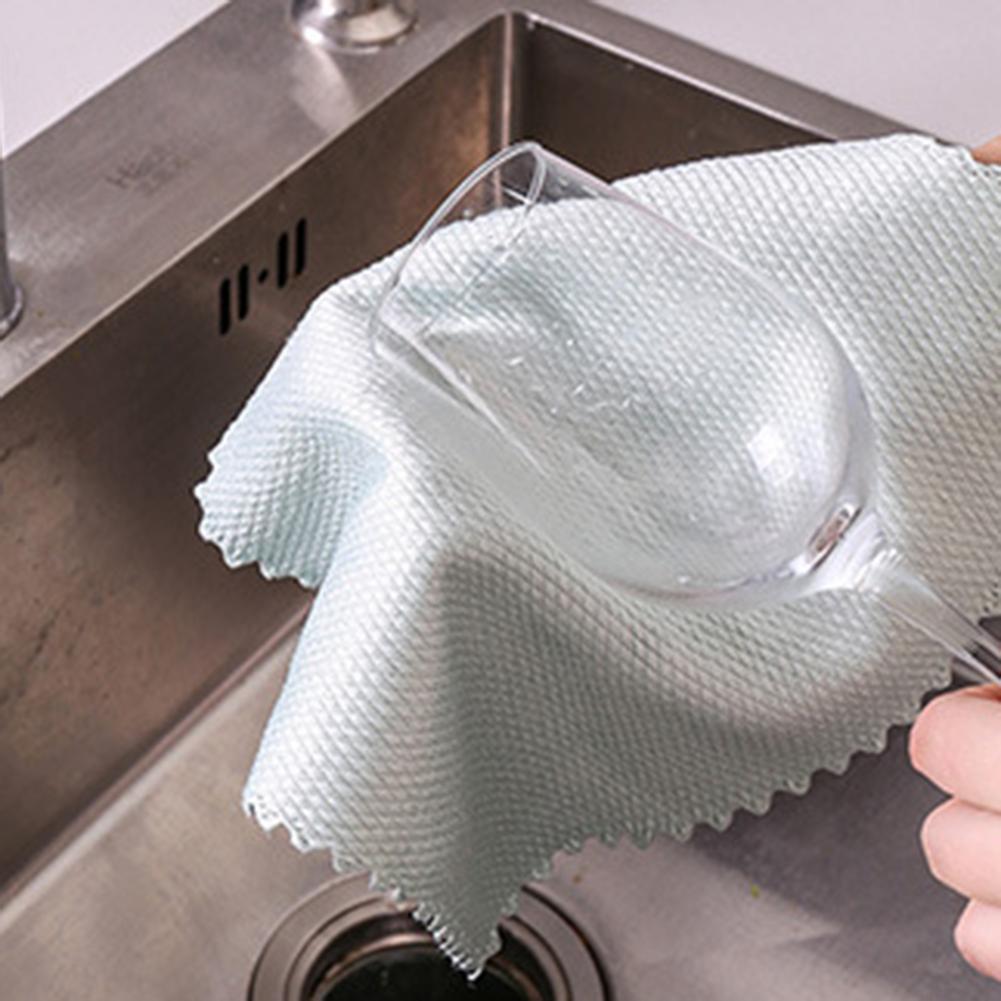 A person cleaning a glass in a sink with the Fish Scale Nano Reusable Cleaning Cloths from the MezoJaoie Wonder Lifestyle Store.