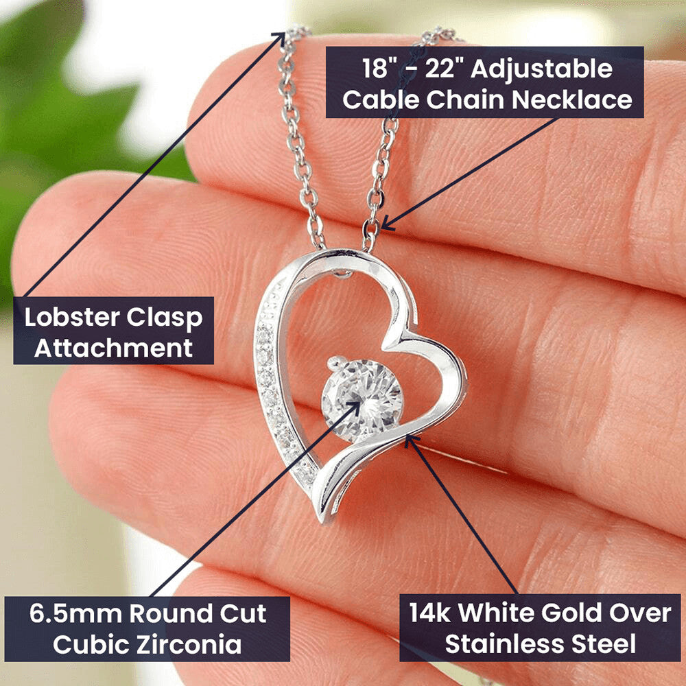 A person is holding a "You Complete Me Forever Love Necklace - To Wife from Husband" from ShineOn Fulfillment, with a heart shaped pendant.