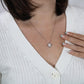 A woman wearing a white sweater and a ShineOn Fulfillment To My Mom - You Are The Only Person - Love Knot Necklace.